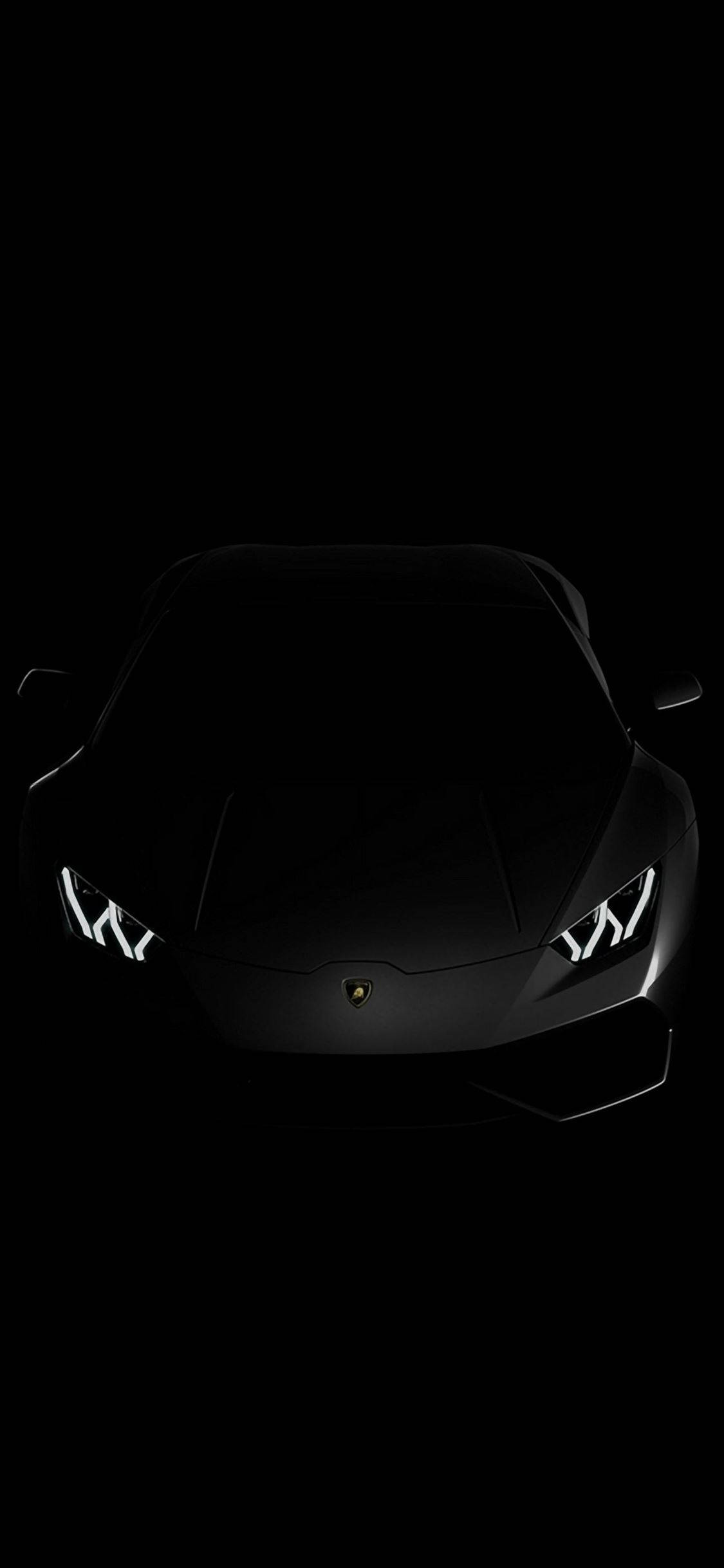野馬車黑色iPhone壁紙 壁紙 — 一架流線型黑色林寶堅尼跑車，在漆黑一片的虛空中，散發出銳利的白色頭燈光芒。