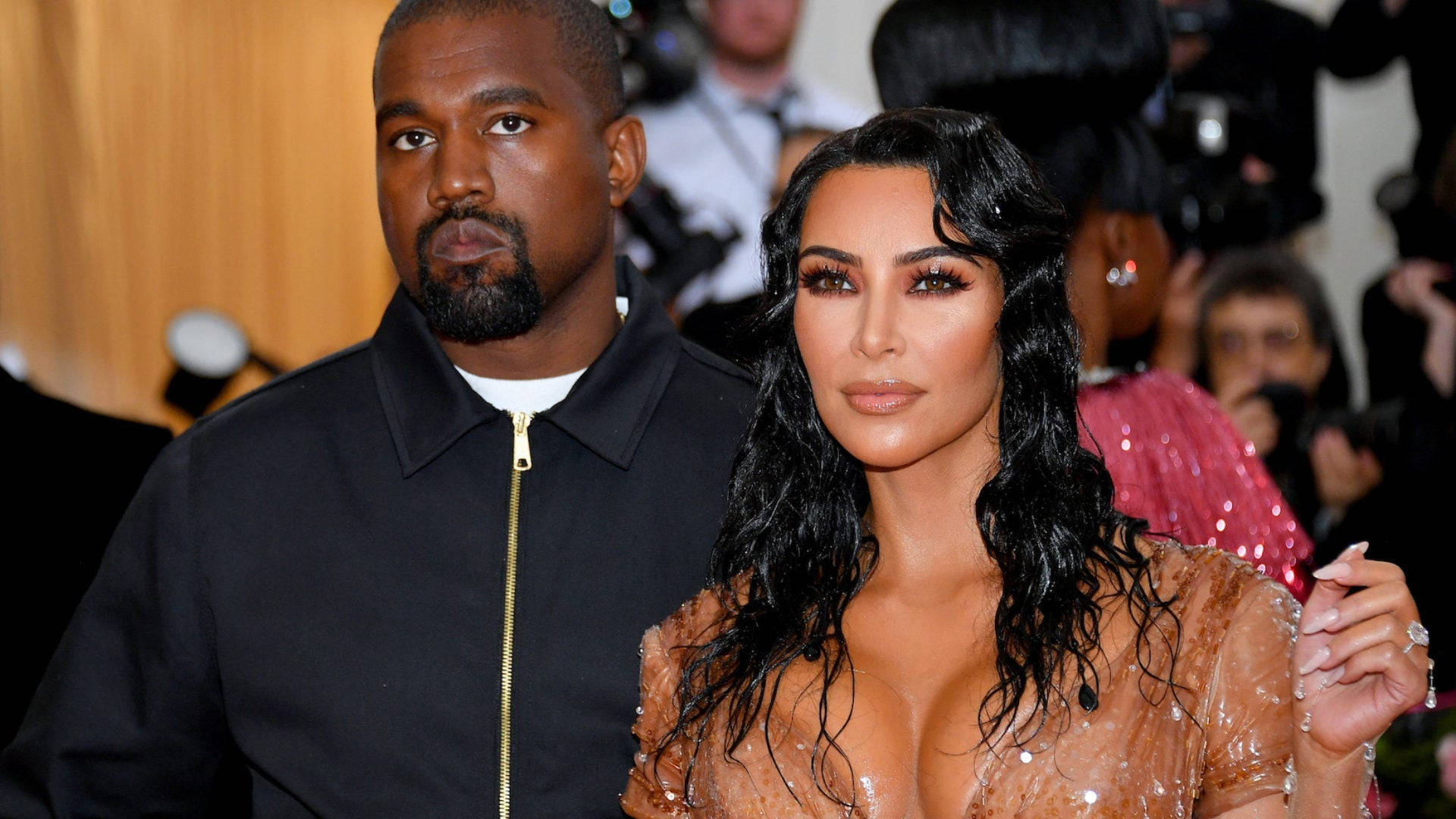 Kanye West 和 Kim Kardashian 在紅地毯活動中，相機閃光燈閃爍。