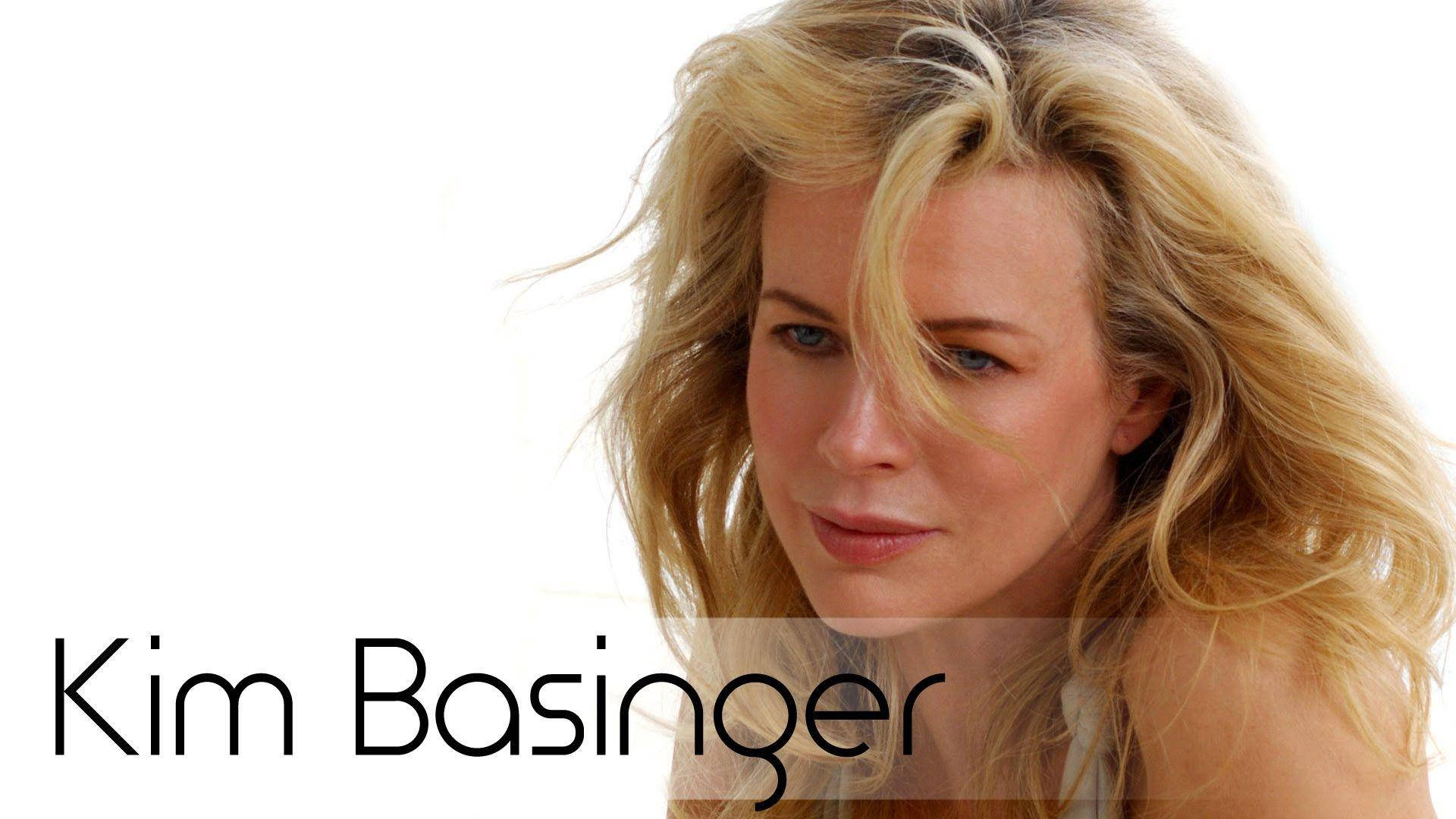 金·貝辛格誘人近照 壁紙 — 金碧辛嘉（Kim Basinger）一頭被風吹拂的金髮，柔和的目光，在純白背景前。