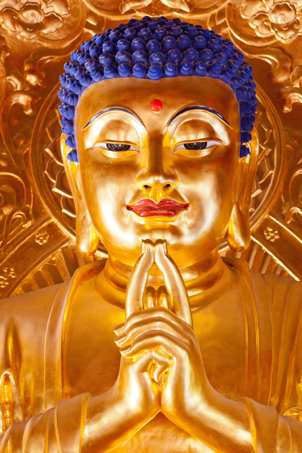 金色佛像，藍色頭髮，雙手合十祈禱姿勢。