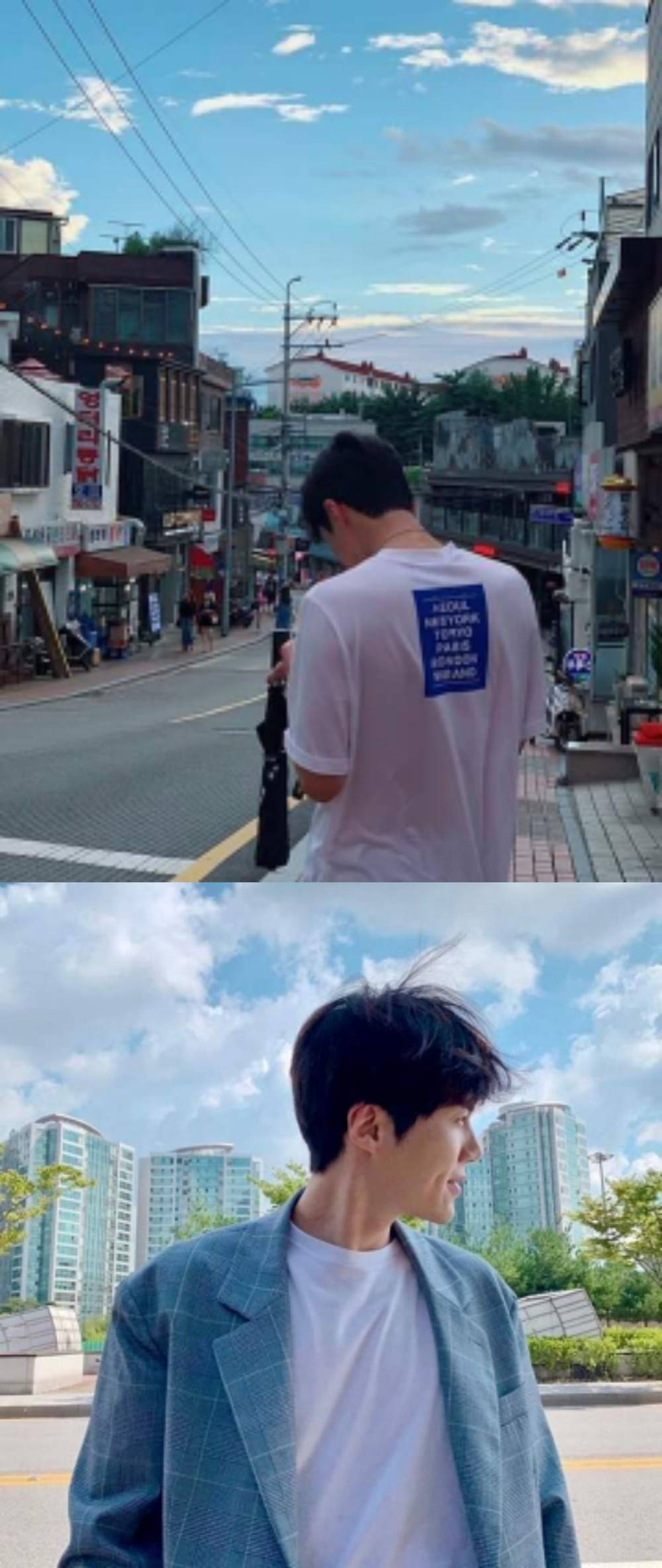 金善浩自然隨拍 壁紙 — 一個年輕男子走在繁華的城市街道上，在明亮的藍天下，以現代高樓大廈為背景微笑站立。