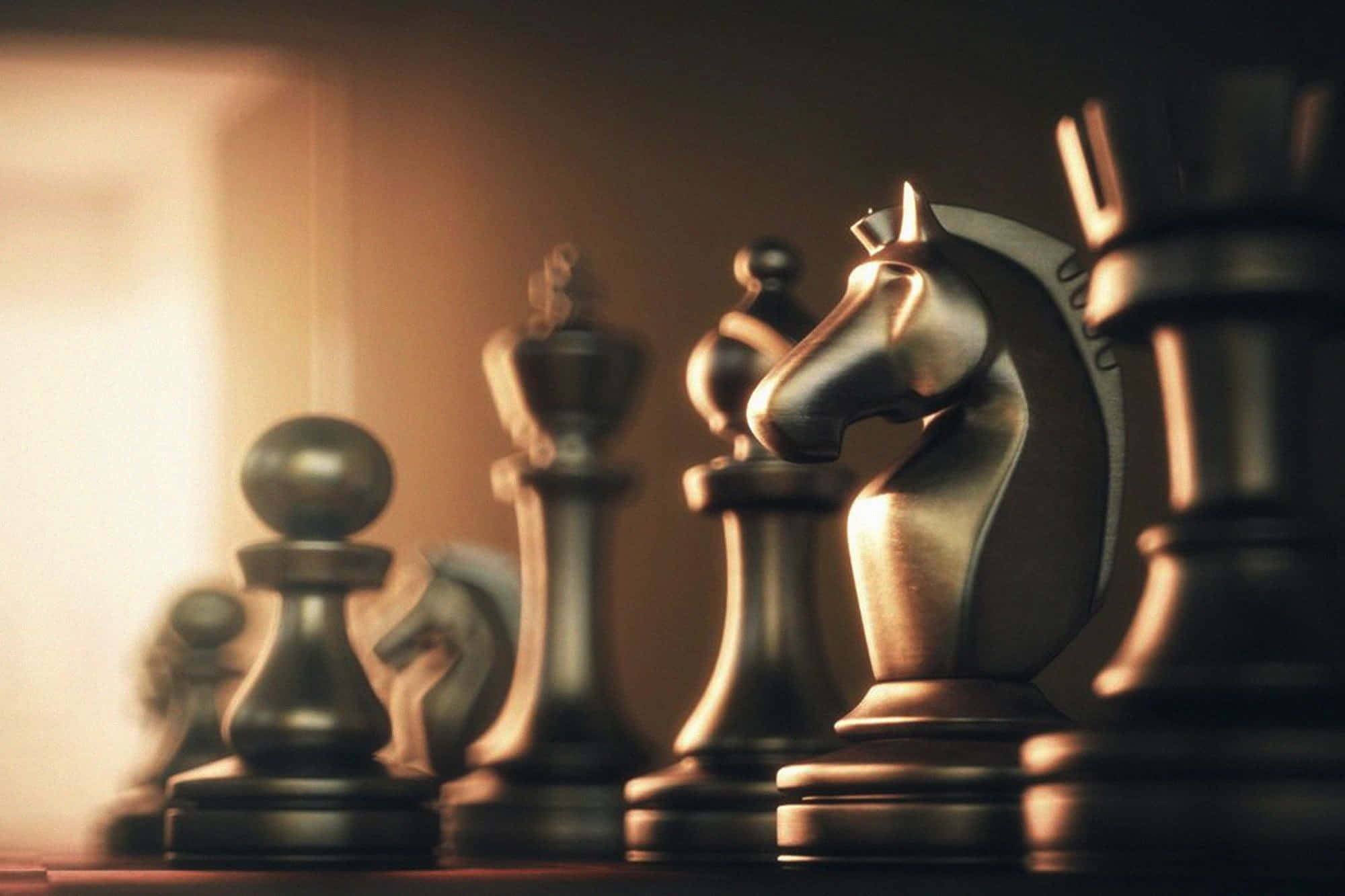 Educational Games 桌布 壁紙 — 金屬國際象棋棋子的特寫，沐浴在溫暖的金色光線中，景深較淺。