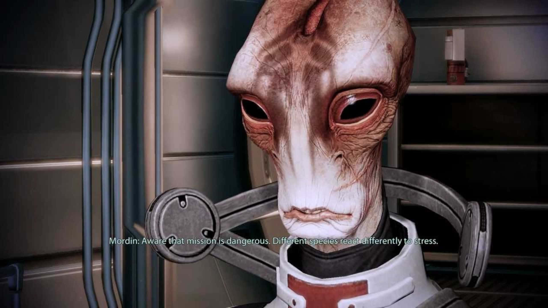 Mordin Solus 桌布 壁紙 — 金屬太空船內部，一個蒼白皮膚、大眼睛、皺紋臉的外星人特寫，穿著白色和紅色的裝甲服。
