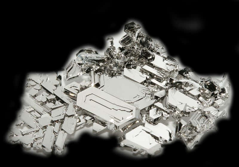金屬晶體結構 壁紙 — 一簇引人注目的金屬銀色晶體在純黑背景上閃耀，帶有銳利的高光和深邃的陰影。