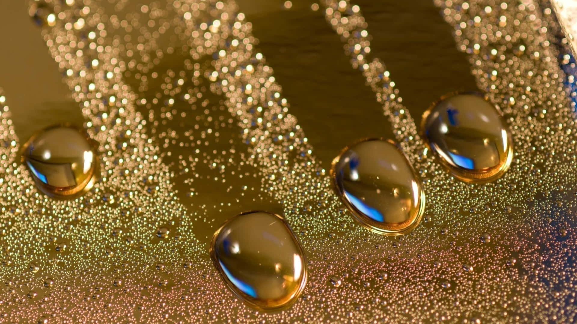 金色水滴在閃爍的紋理表面上反射藍光。