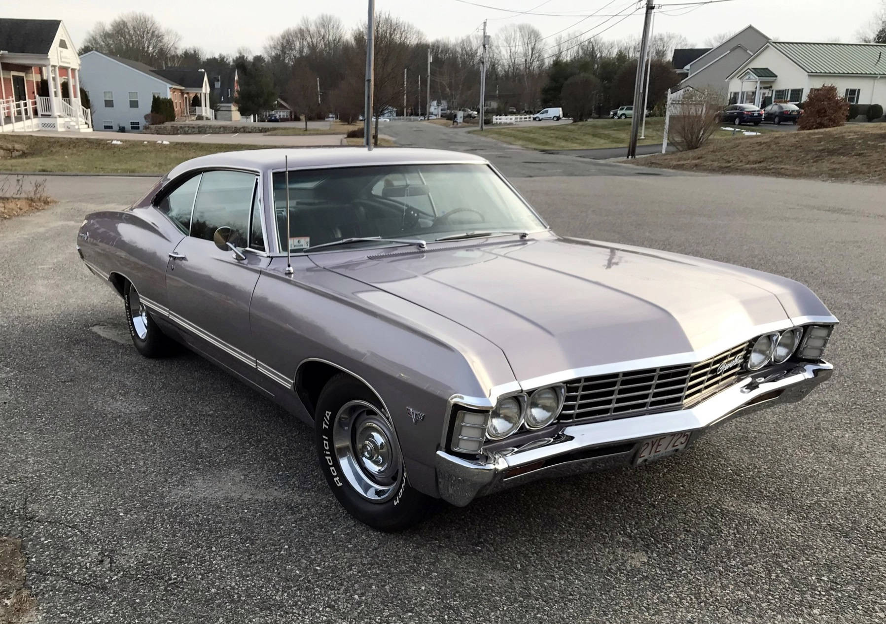 金屬灰雪佛蘭Impala 1967 壁紙 — 一架流線型銀色經典肌肉車停泊在寧靜的住宅街道上，背景有房屋和光禿禿的樹木。