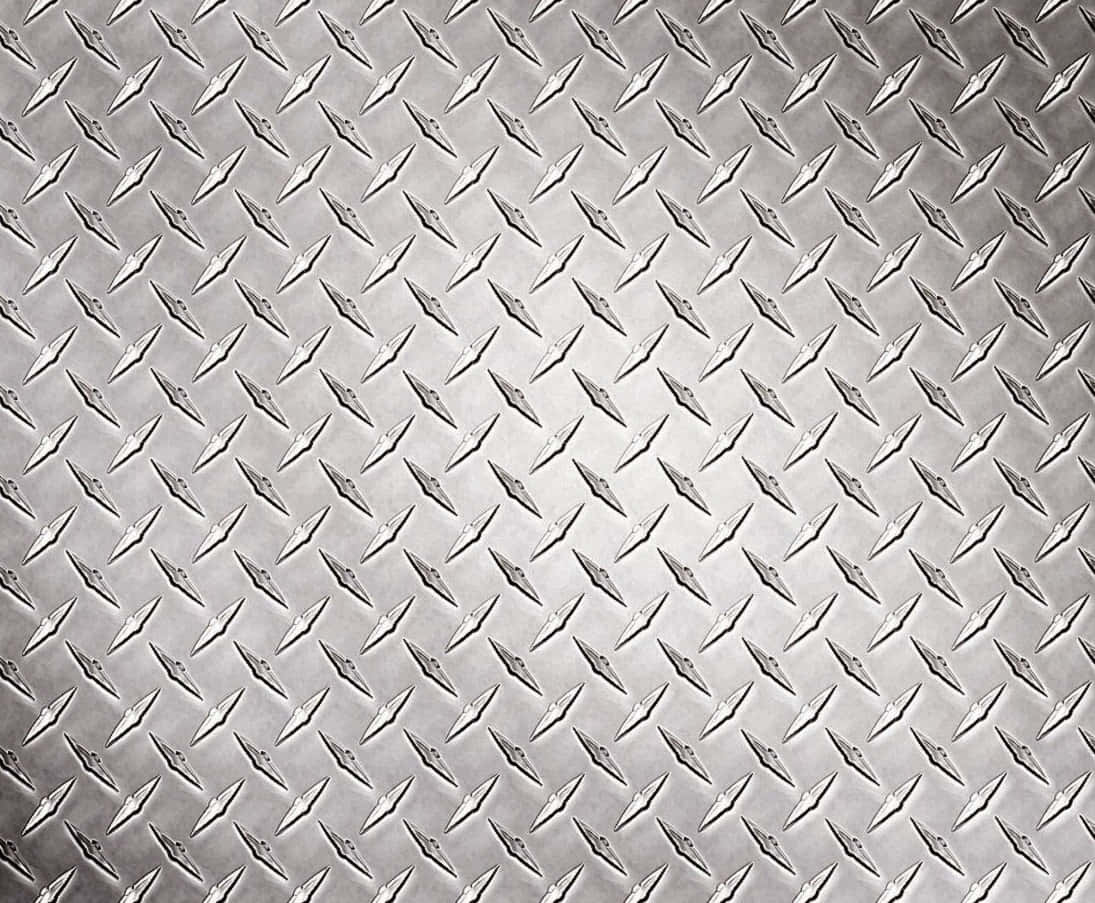 Diamond Plate 桌布 壁紙 — 金屬菱形板表面的特寫，在均勻照明下呈現重複的凸起菱形圖案。