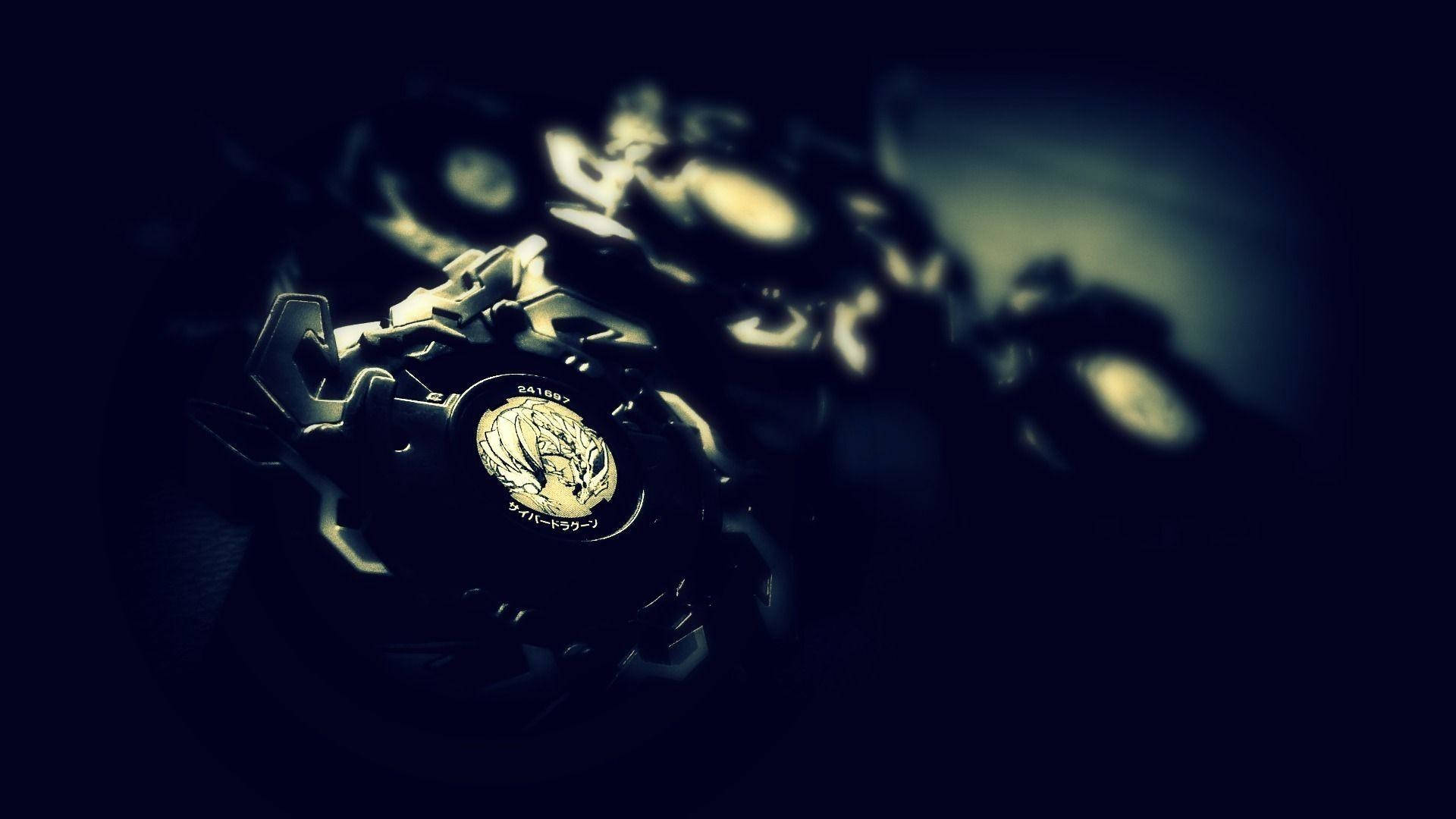 Beyblade 桌布 壁紙 — 金屬製Beyblade嘅特寫，帶有發光金色點綴，背景係暗色模糊。
