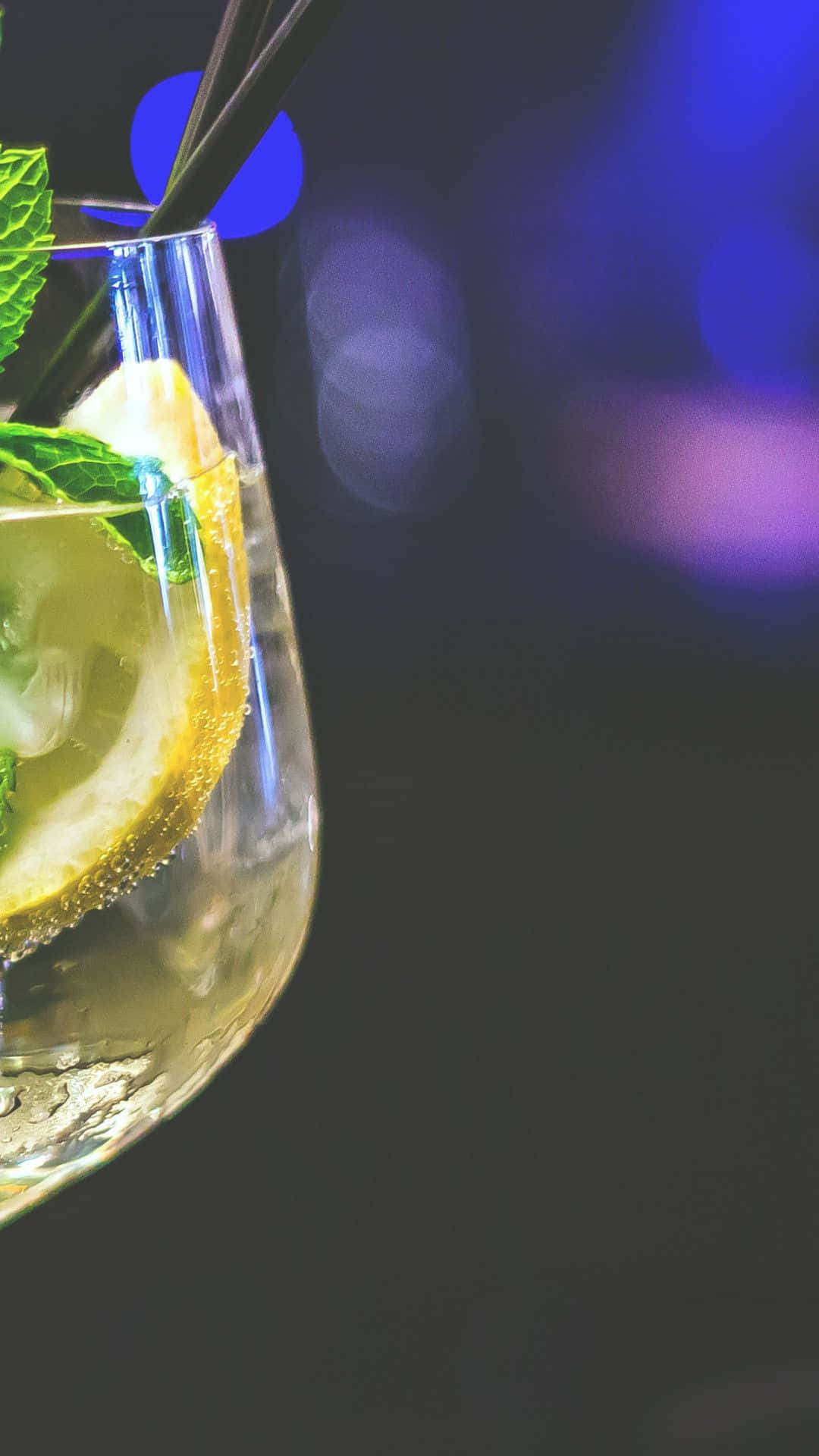 酒吧中一杯冰涼的檸檬薄荷飲料，杯中有冰塊和吸管。