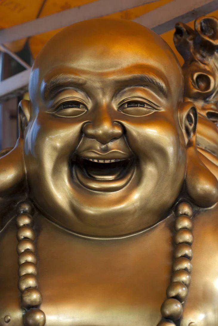 戴著珠串項鍊的金色笑佛雕像