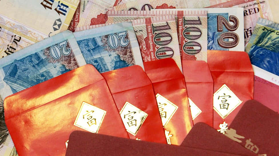 Red Envelope 桌布 壁紙 — 金色「福」字的紅色利是封放在散落的港幣鈔票上。