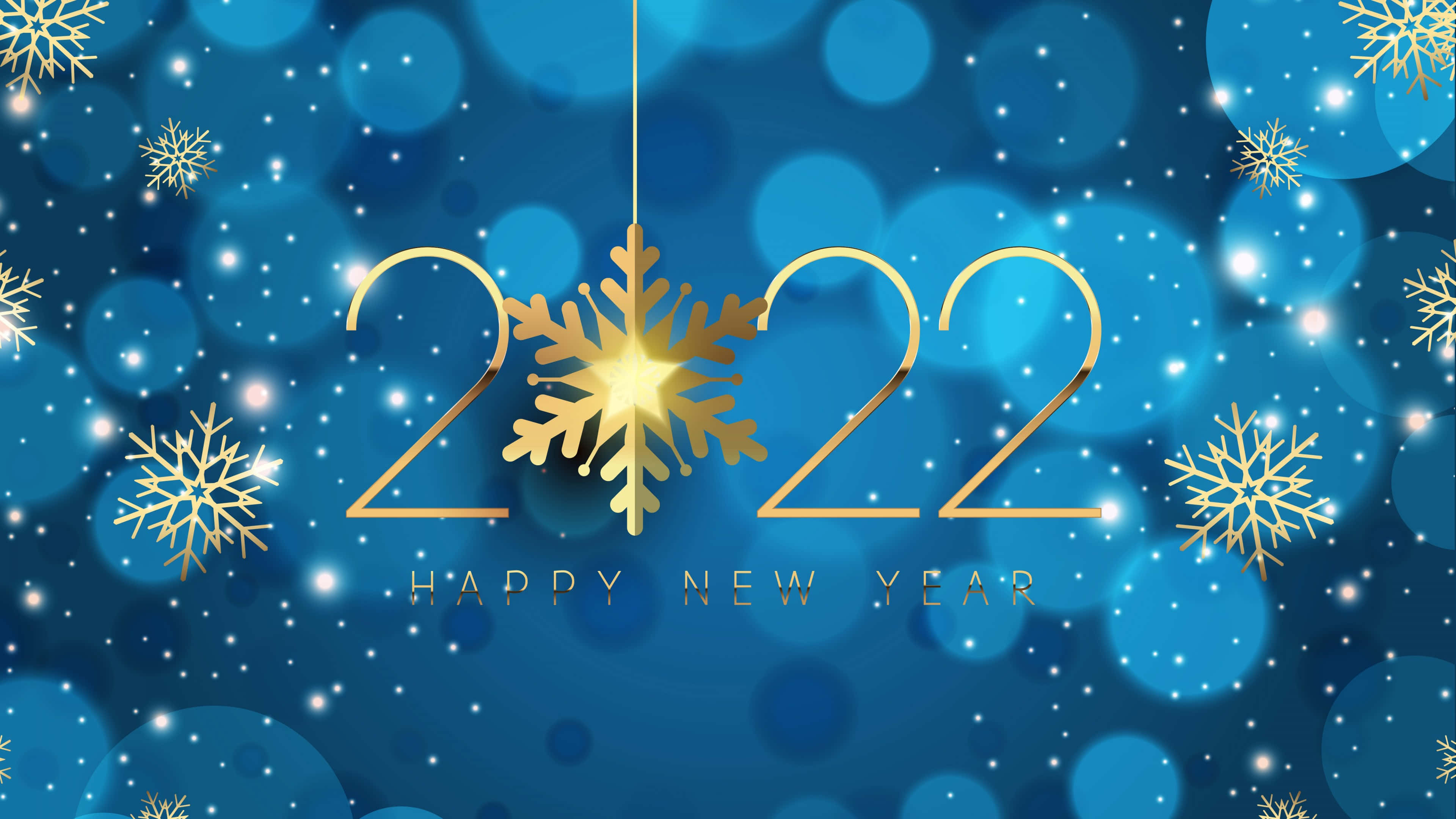 Happy New Year 2022 桌布 壁紙 — 金色2022新年文字，中心有雪花，懸掛在閃爍的藍色散景背景上。