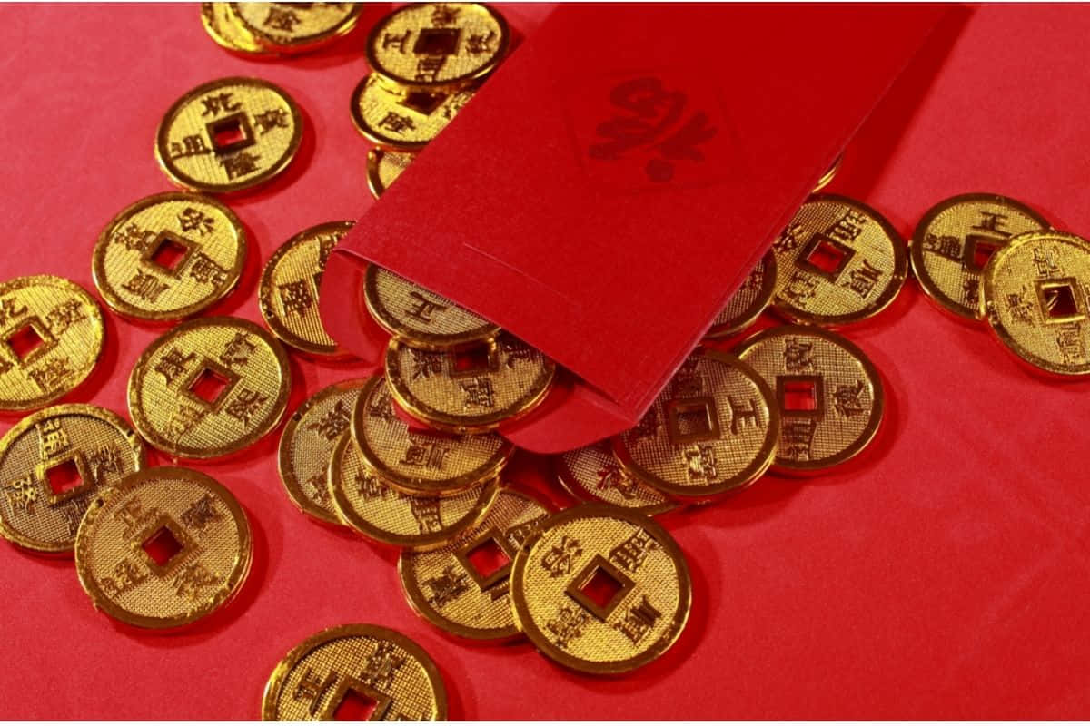 Red Envelope 桌布 壁紙 — 金色中國硬幣從紅色利是封中溢出，落在鮮紅色的表面上，象徵繁榮與慶祝。