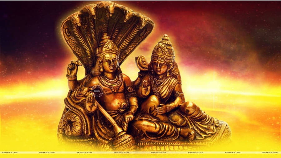Vishnu 桌布 壁紙 — 金色印度教神像在燦爛天光下寧靜端坐，背景是熾熱的日落。