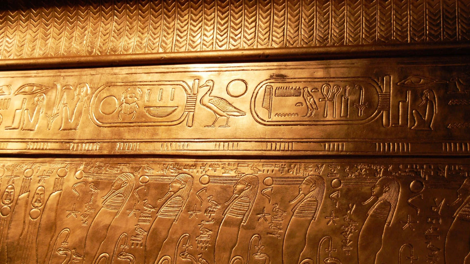 Egypt 桌布 壁紙 — 金色古埃及牆板，在溫暖燈光下呈現精細象形文字和人物。