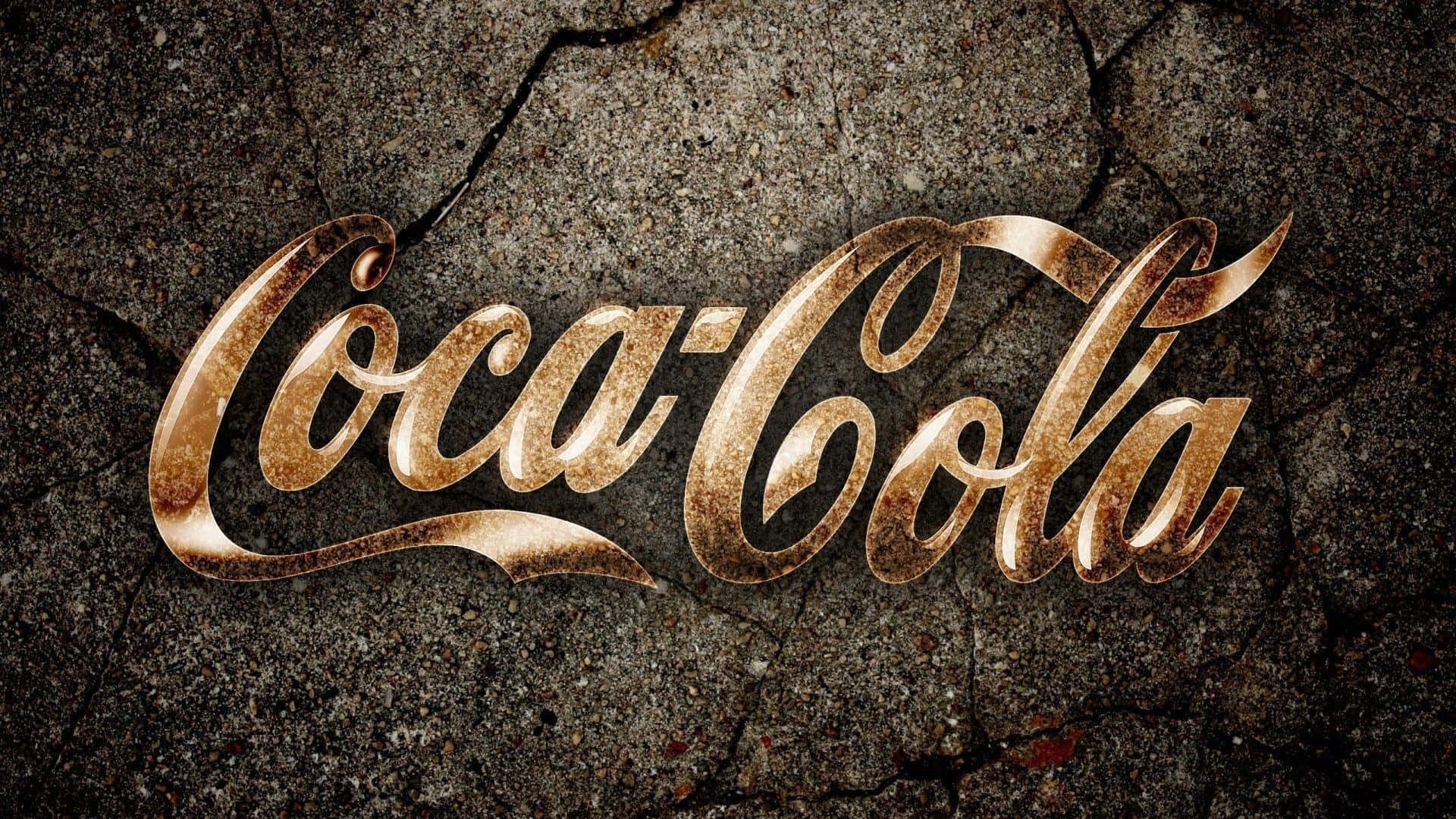 coca cola 桌布 壁紙 — 金色可口可樂草書標誌在裂紋混凝土上閃耀，帶有粗糙質感和溫暖金屬光澤。