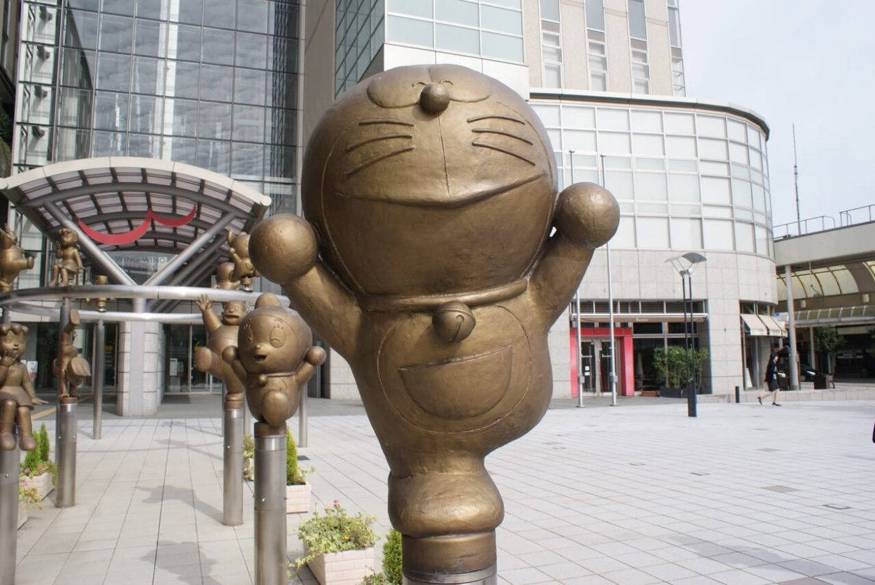 城市廣場上嘅多啦A夢銅像，背景有玻璃建築。