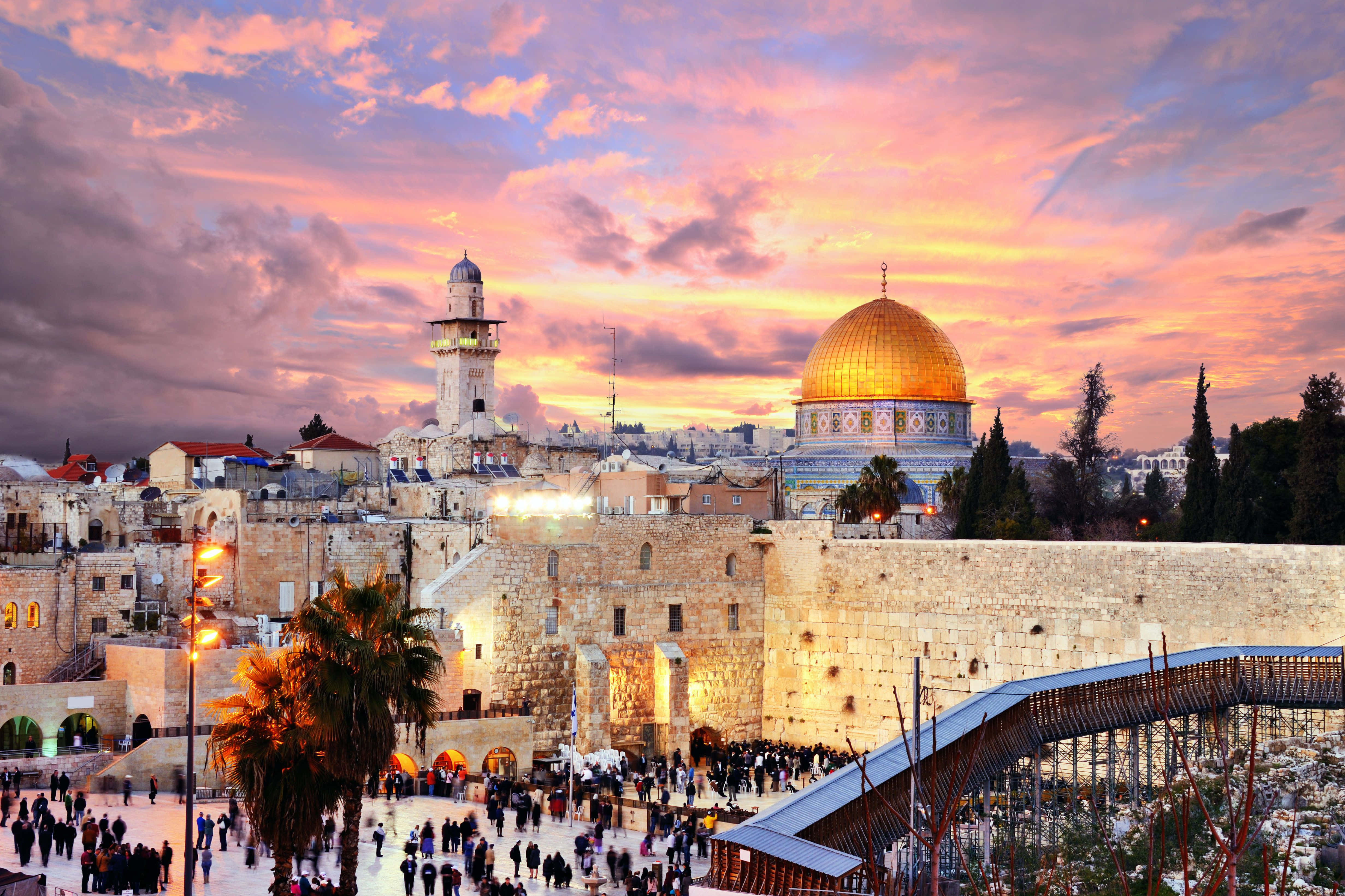 Holy Land 桌布 壁紙 — 金色圓頂岩石寺在耶路撒冷古老石牆和熙攘人群之上，於火紅夕陽天空下閃耀。