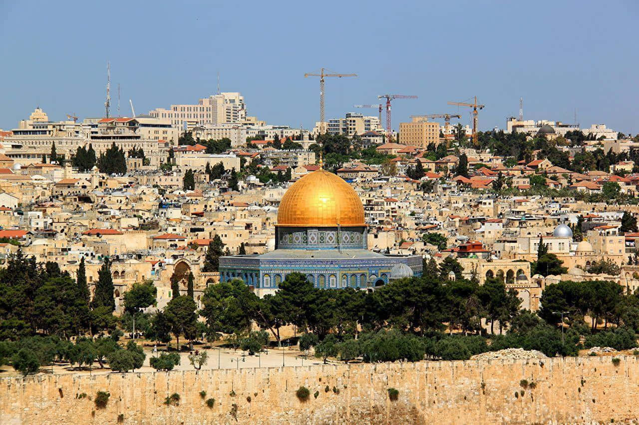 Israel 桌布 壁紙 — 金色圓頂岩石寺在藍天白雲下，於一座被古老石建築和現代起重機環繞的山丘頂上閃耀。