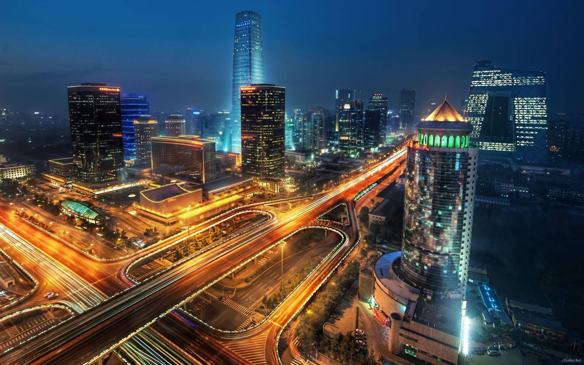 夜間城市，摩天大樓亮起，高速公路上有發光的交通軌跡。