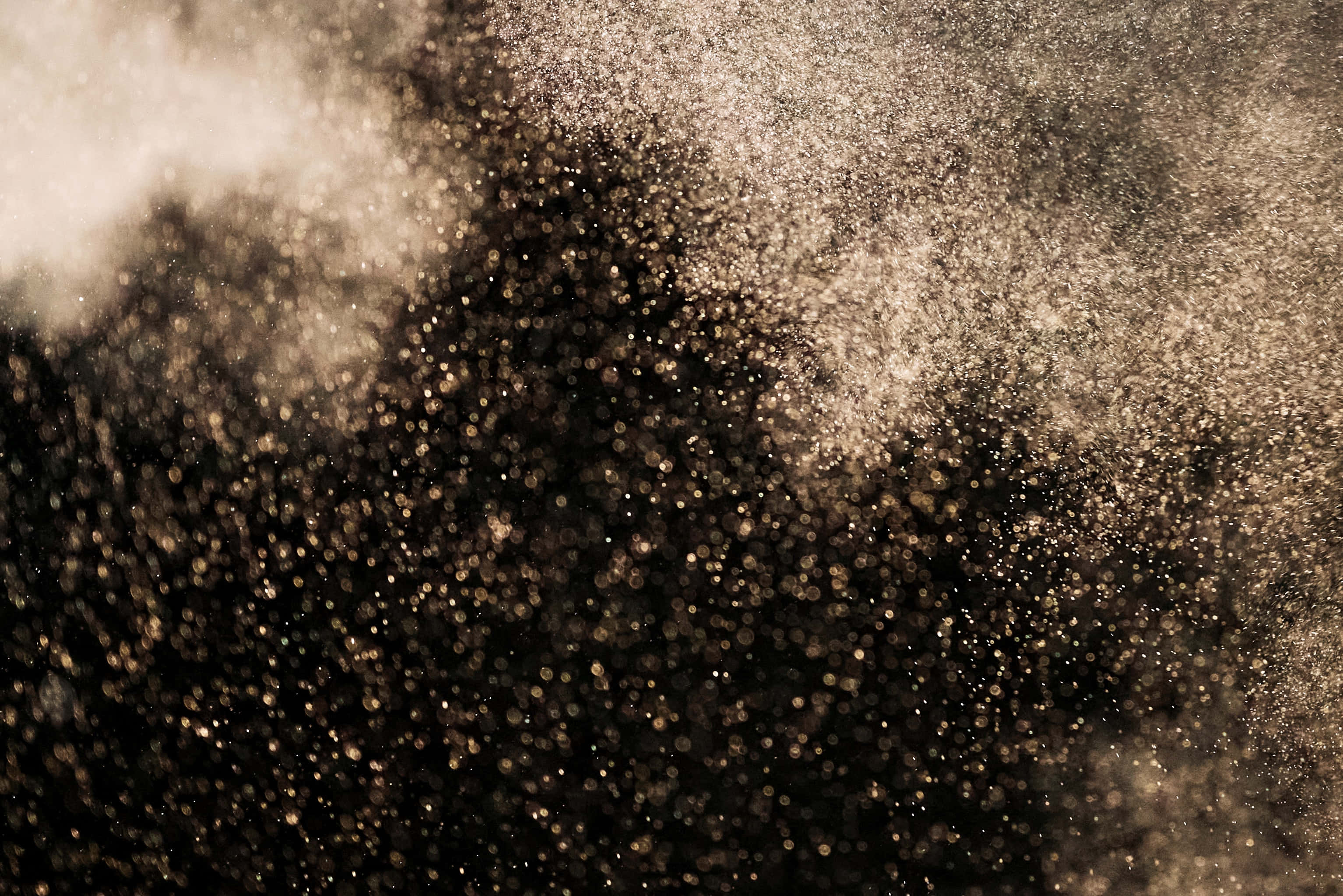 Dust 桌布 壁紙 — 金色塵埃粒子在黑暗背景下爆炸，營造出動感且富有紋理的抽象場景。