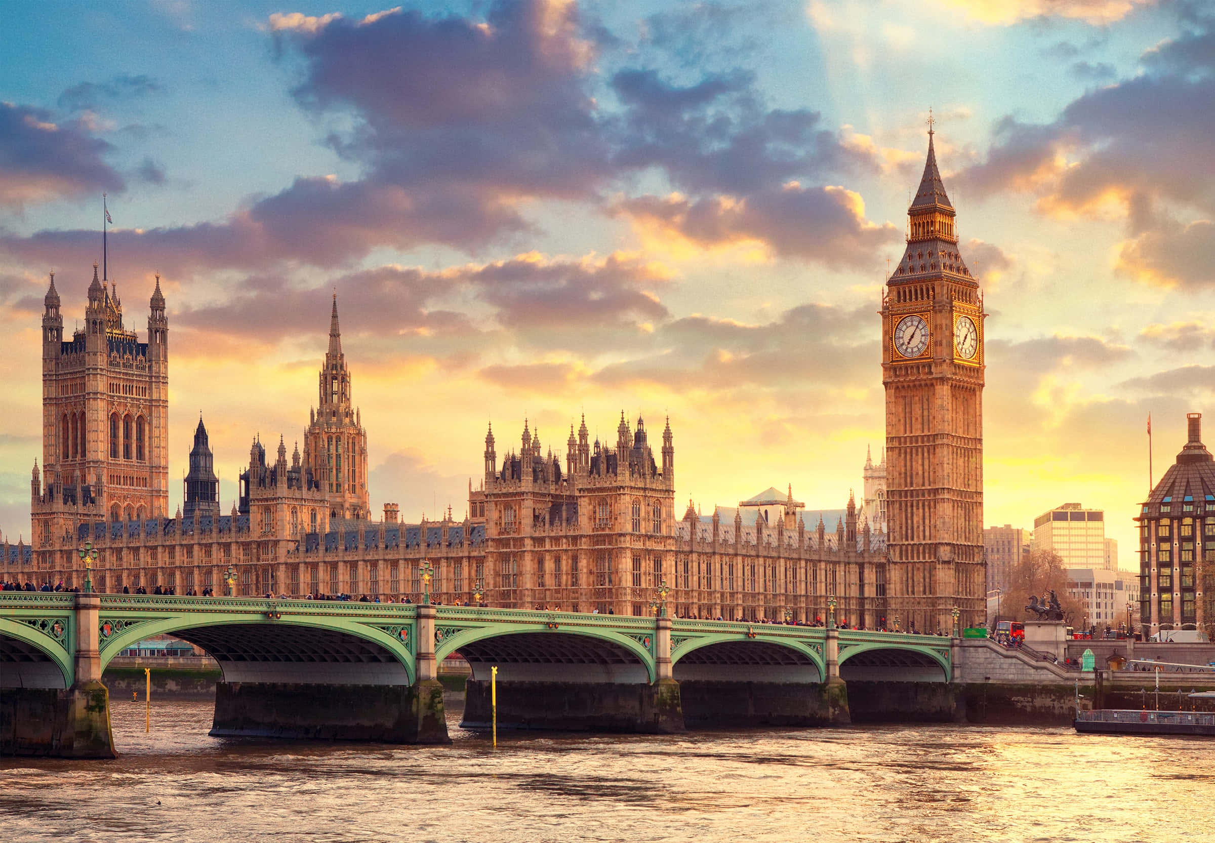 UK 桌布 壁紙 — 金色夕陽以溫暖的光芒沐浴著標誌性的伊麗莎白塔和國會大廈，泰晤士河在威斯敏斯特橋下流淌。