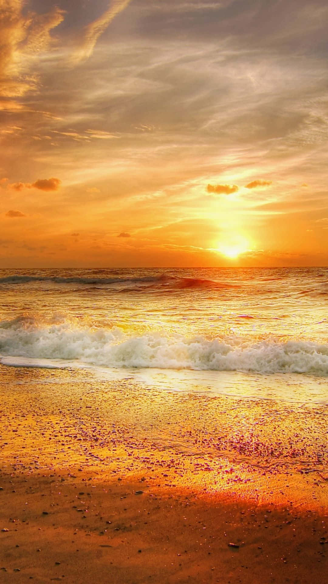 Yellow Sky 桌布 壁紙 — 金色夕陽以溫暖色調描繪海洋和沙灘，海浪拍打著海岸。