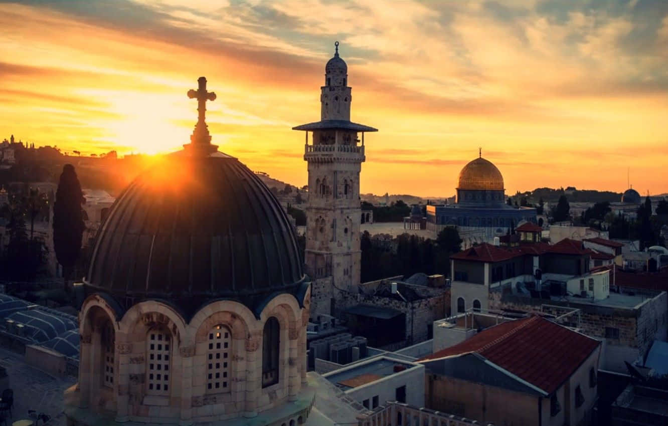 Holy Land 桌布 壁紙 — 金色夕陽沐浴耶路撒冷的歷史圓頂和宣禮塔，溫暖光線中陽光穿透雲層。