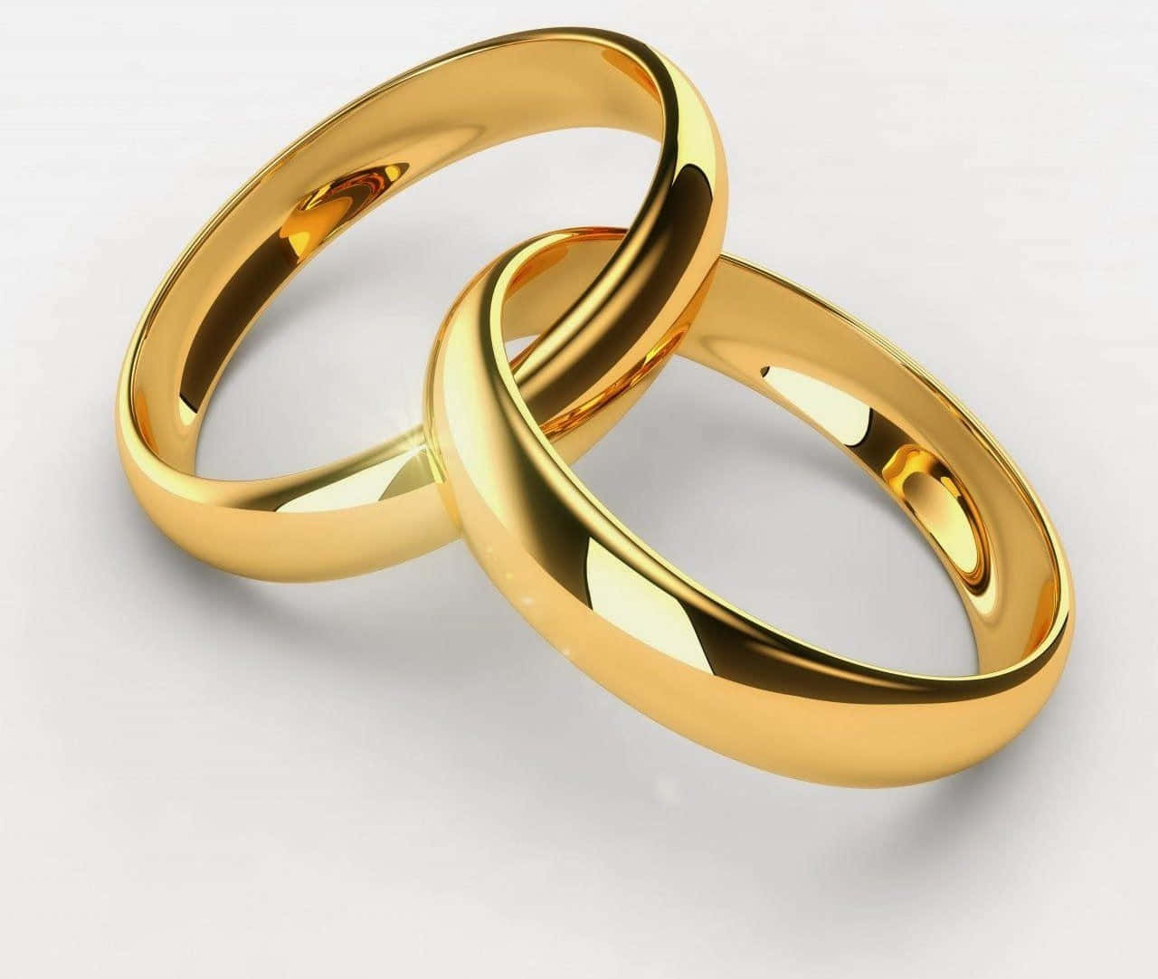 金色婚戒 壁紙 — 兩枚閃閃發光的金色結婚戒指在柔軟的白色表面上交織，以拋光優雅反射光線。