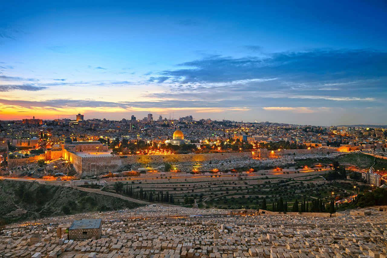 Israel 桌布 壁紙 — 金色岩石圓頂在溫暖燈光的古老石城上空，於暮色天空中閃耀。