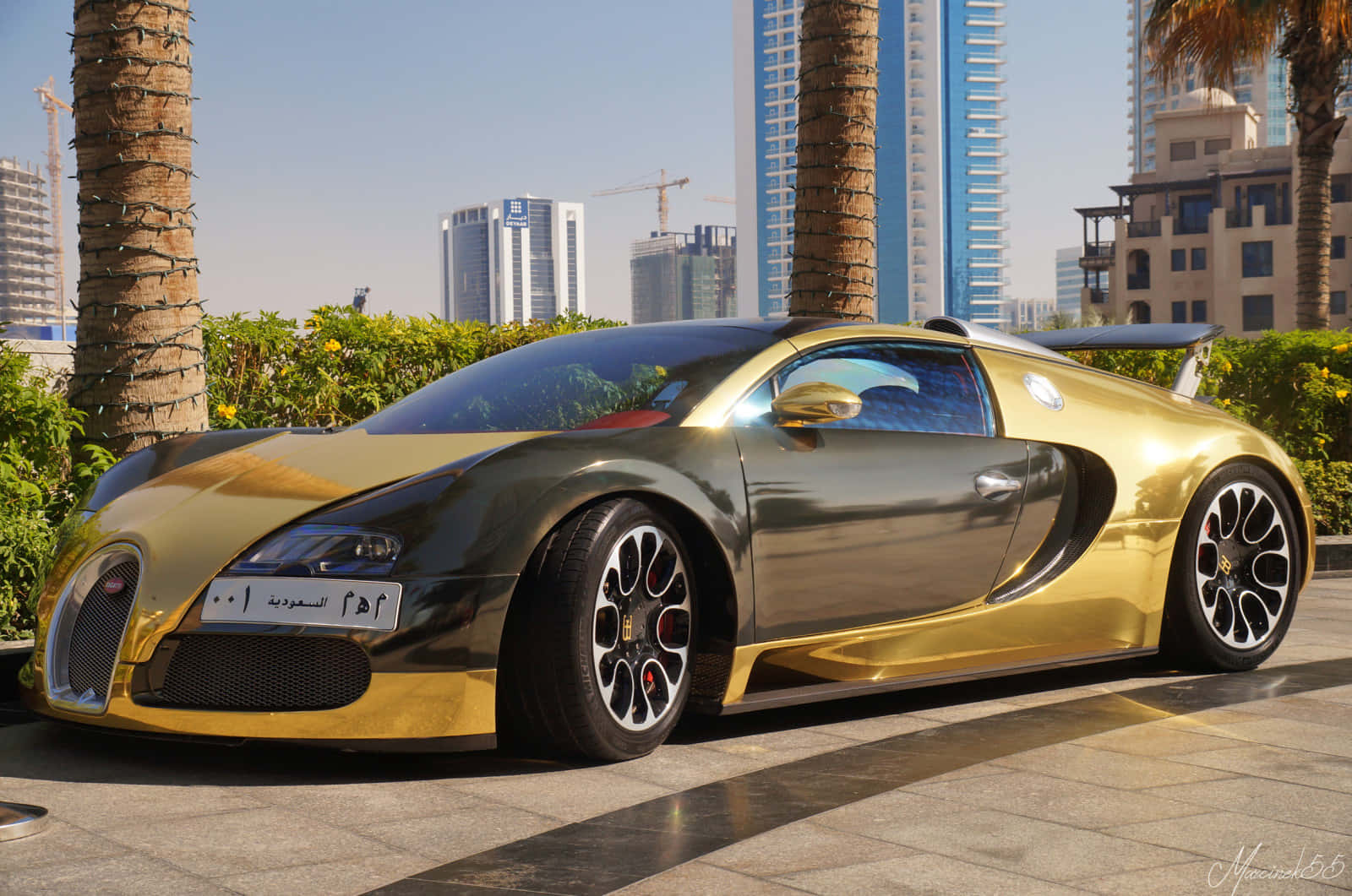 金色Bugatti Veyron停泊在棕櫚樹和摩天大樓的都市環境中。