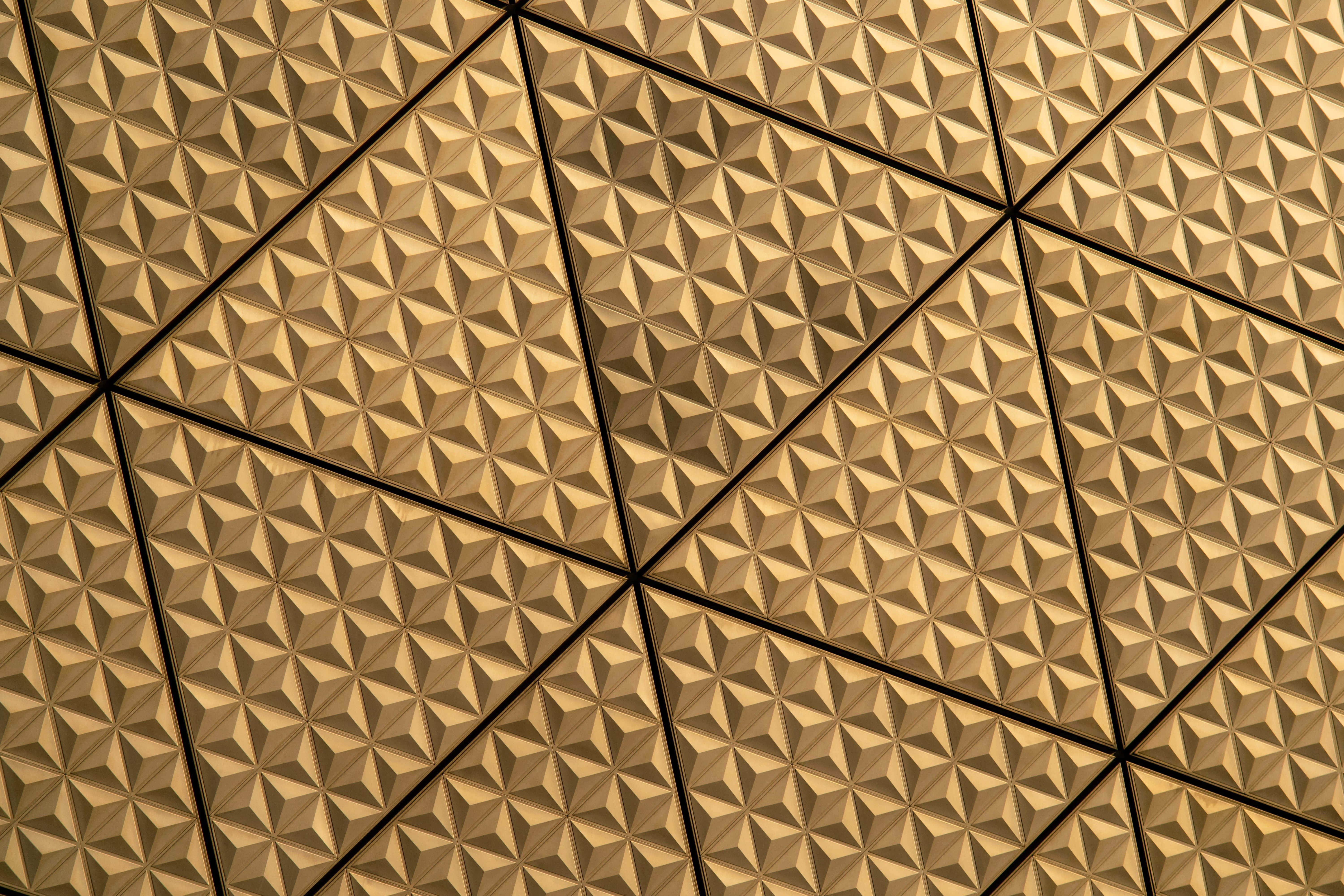 Yellow Triangle 桌布 壁紙 — 金色幾何三角形面板形成重複的3D圖案，並以深色線條劃分區域。