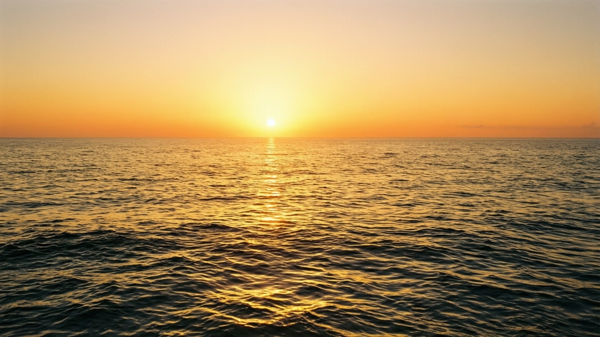 平靜海面上的夕陽，帶有金色倒影