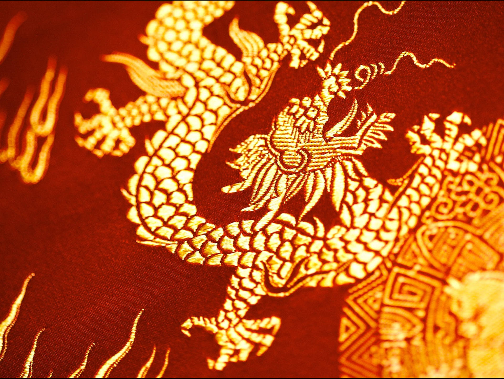 金色東方龍織錦 壁紙 — 特寫鏡頭，一條精緻刺繡的金龍在濃郁的紅色布料上，帶有細緻的鱗片和飄逸的鬃毛。