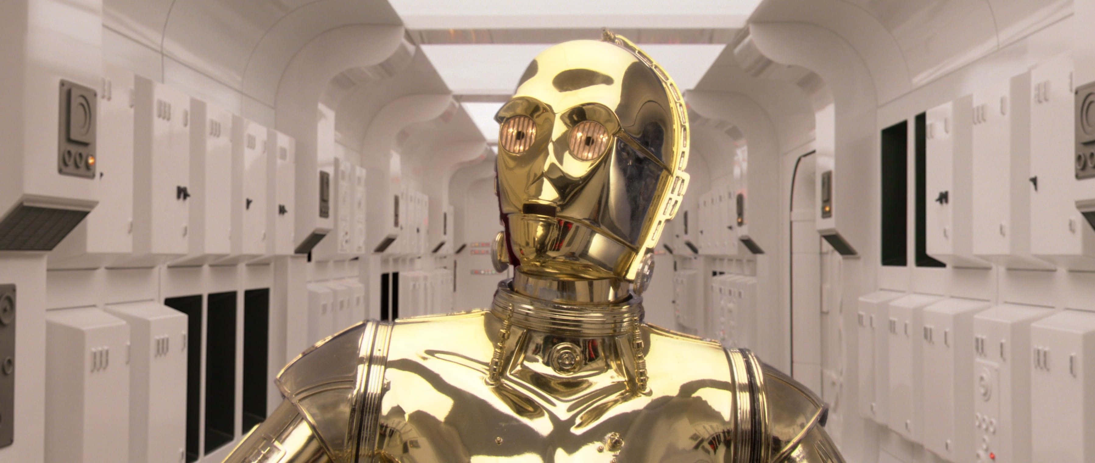 C-3po 桌布 壁紙 — 金色機械人 C-3PO 站在一個無菌的白色走廊，兩旁是伺服器機架，上方有明亮的燈光。