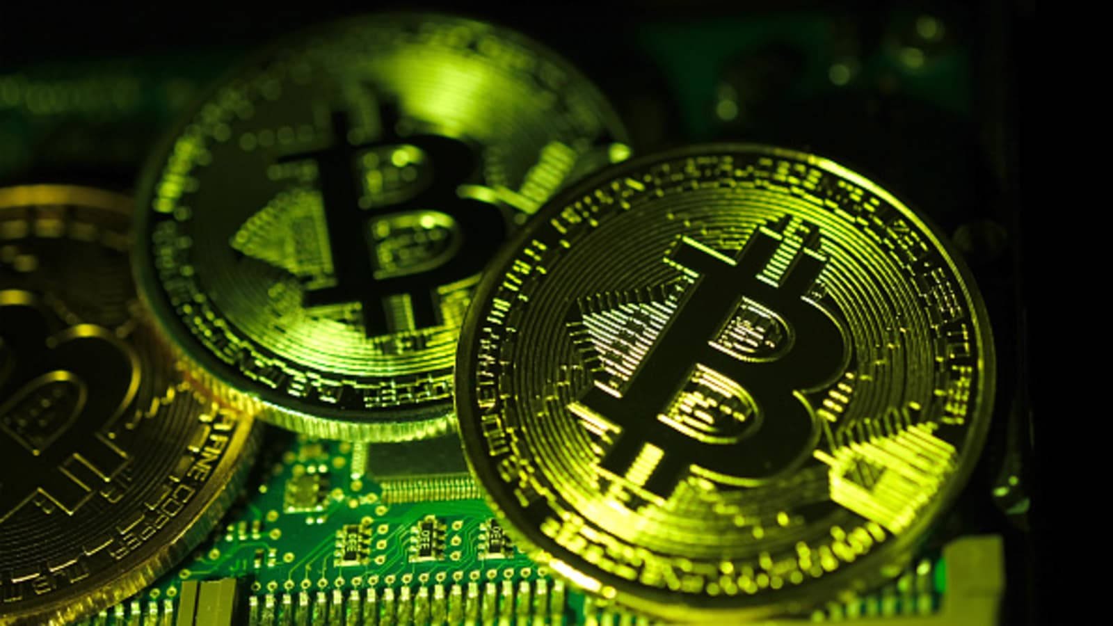 在綠色電路板上發光的金色比特幣。 — 比特幣 壁紙