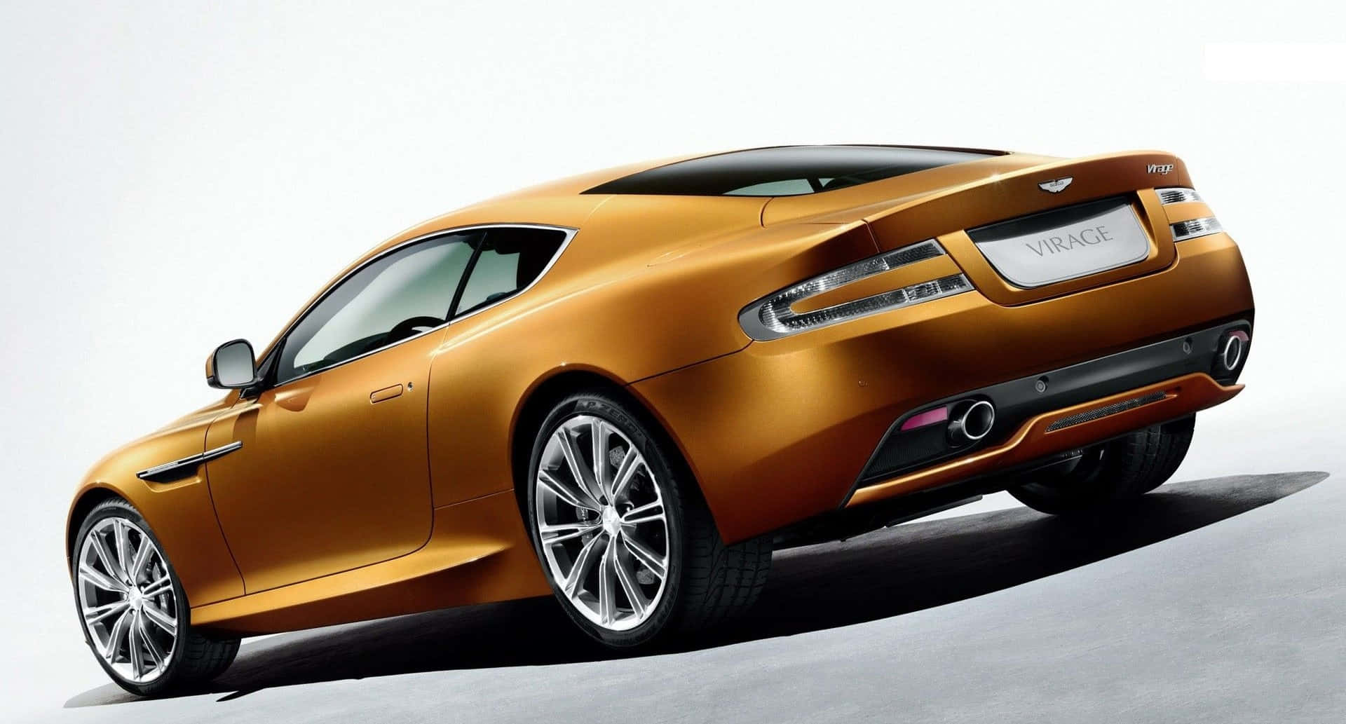 金色汽車處於靜態無神狀態 壁紙 — 一輛時尚的金色 Aston Martin Virage 雙門轎跑車在工作室燈光下以潔白背景展示。