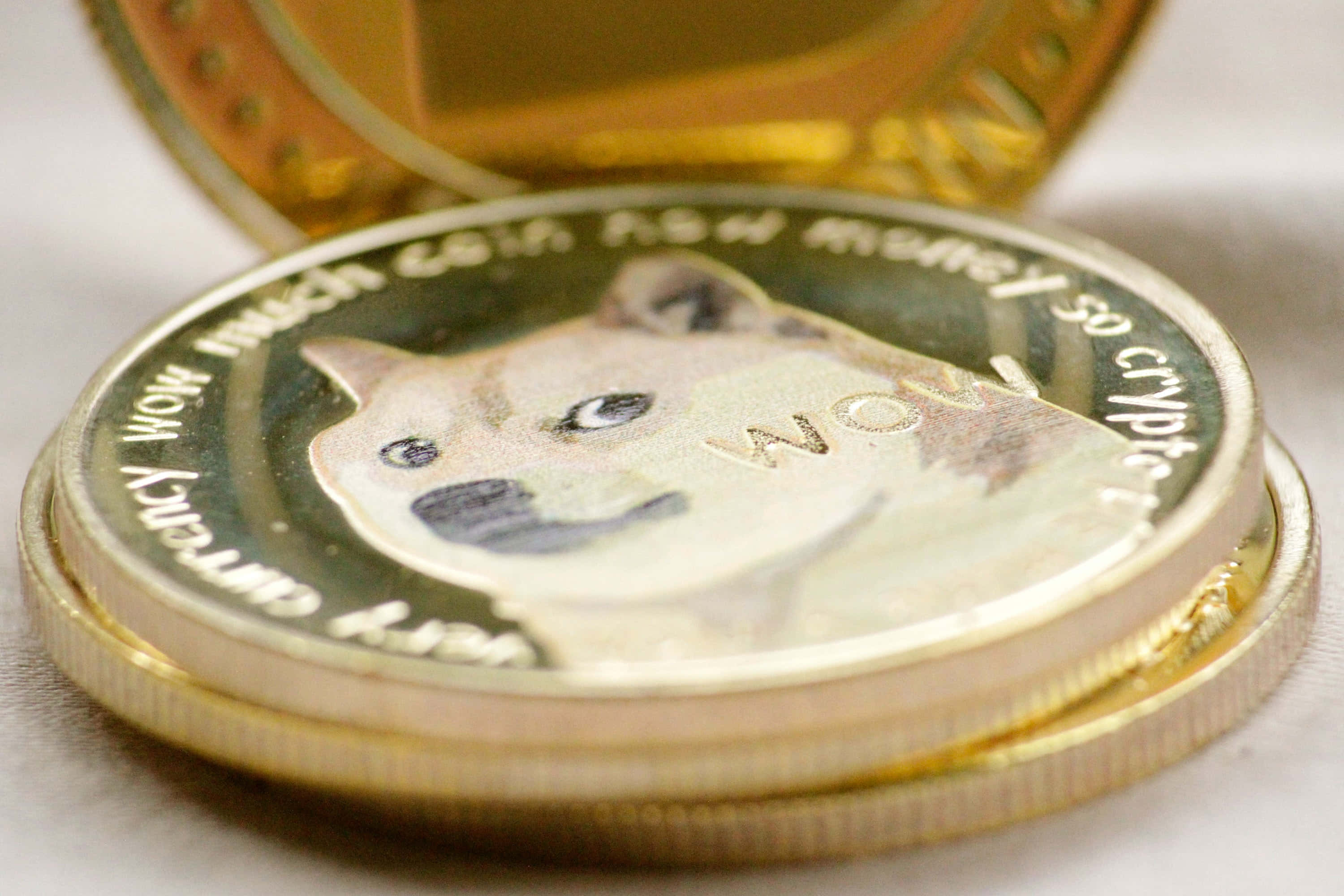 Dogecoin 桌布 壁紙 — 金色狗狗幣的特寫，表面有柴犬臉孔和刻字。