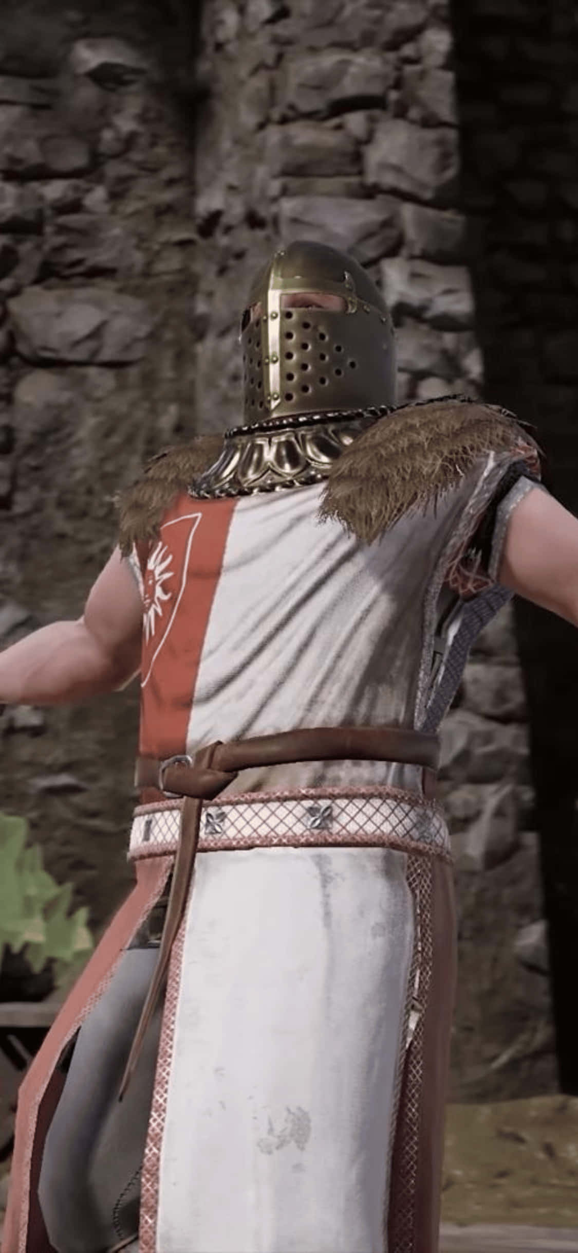 金色盔甲戰士肖像 iPhone XS Mordhau 背景 壁紙 — 一位中世紀騎士，戴著穿孔頭盔，穿著毛皮鑲邊盔甲，站在石牆前。