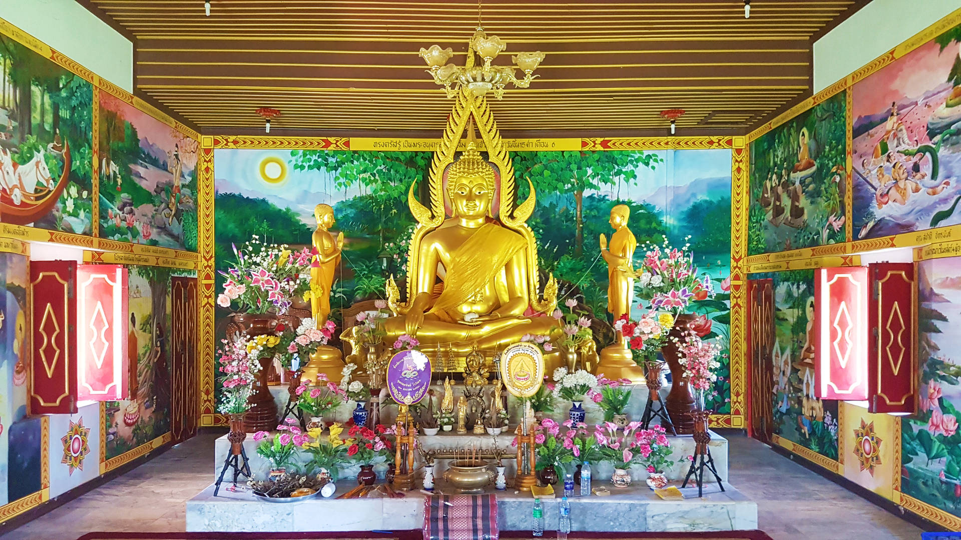 金色佛像在寺廟中被鮮花和宗教供品環繞。