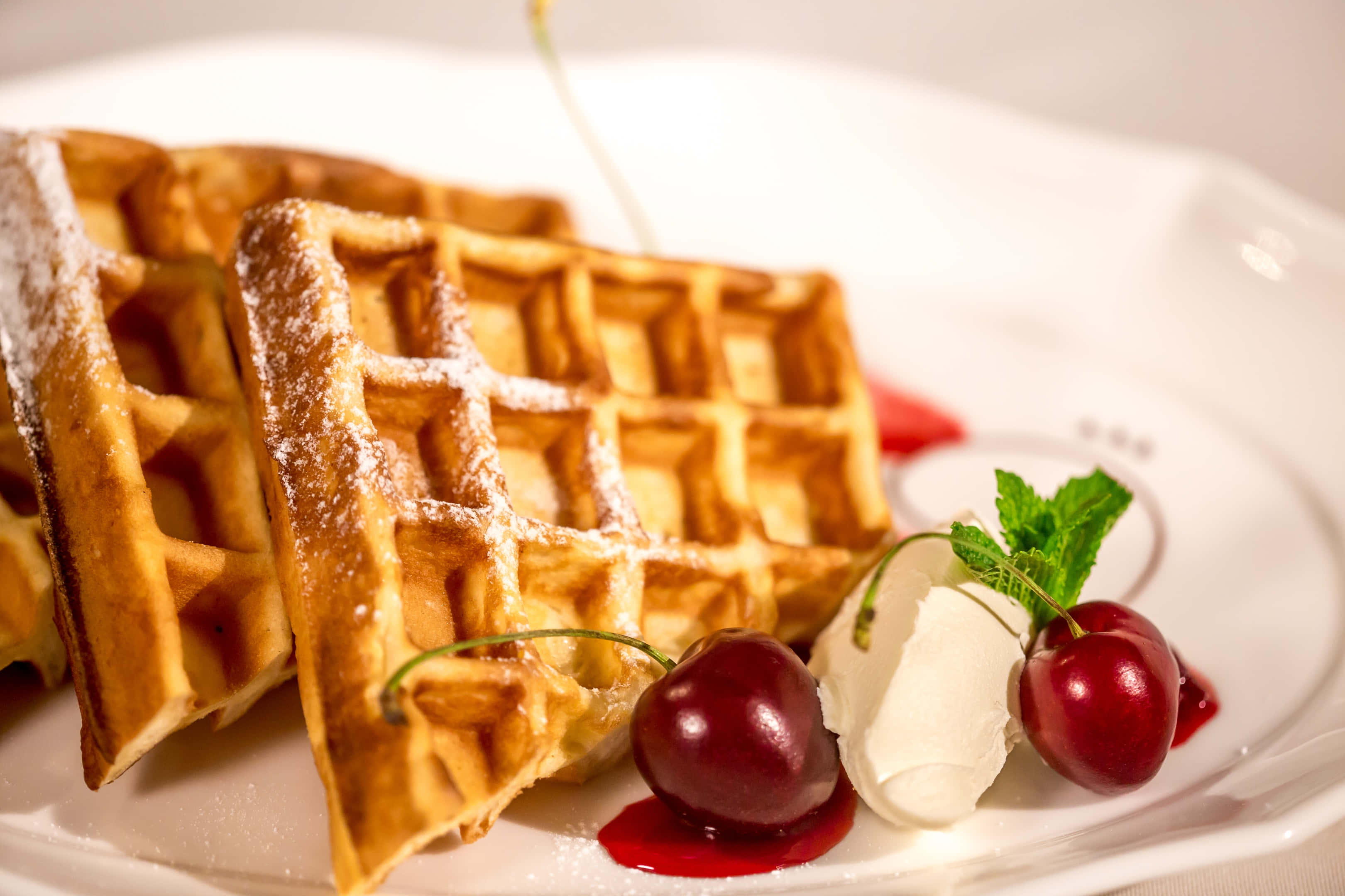 Waffle 桌布 壁紙 — 金色窩夫撒上糖霜，配上櫻桃忌廉和薄荷，放在白色碟上。