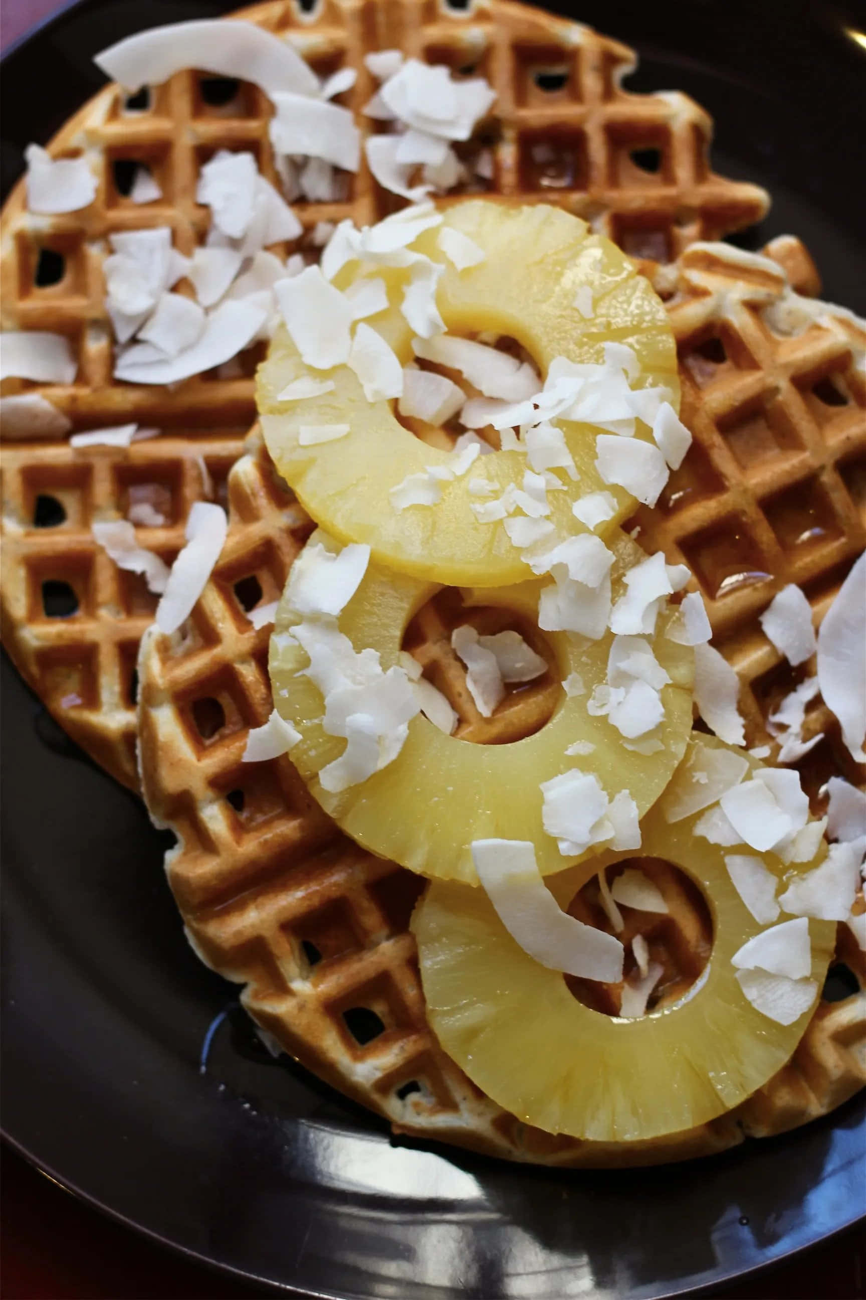 Waffle 桌布 壁紙 — 金色窩夫配上多汁菠蘿圈和甜椰絲，放在深色碟上。