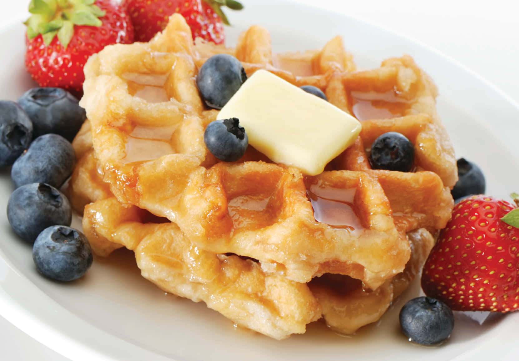 Waffle 桌布 壁紙 — 金色窩夫配上牛油糖漿、藍莓和草莓，放在白色碟上。