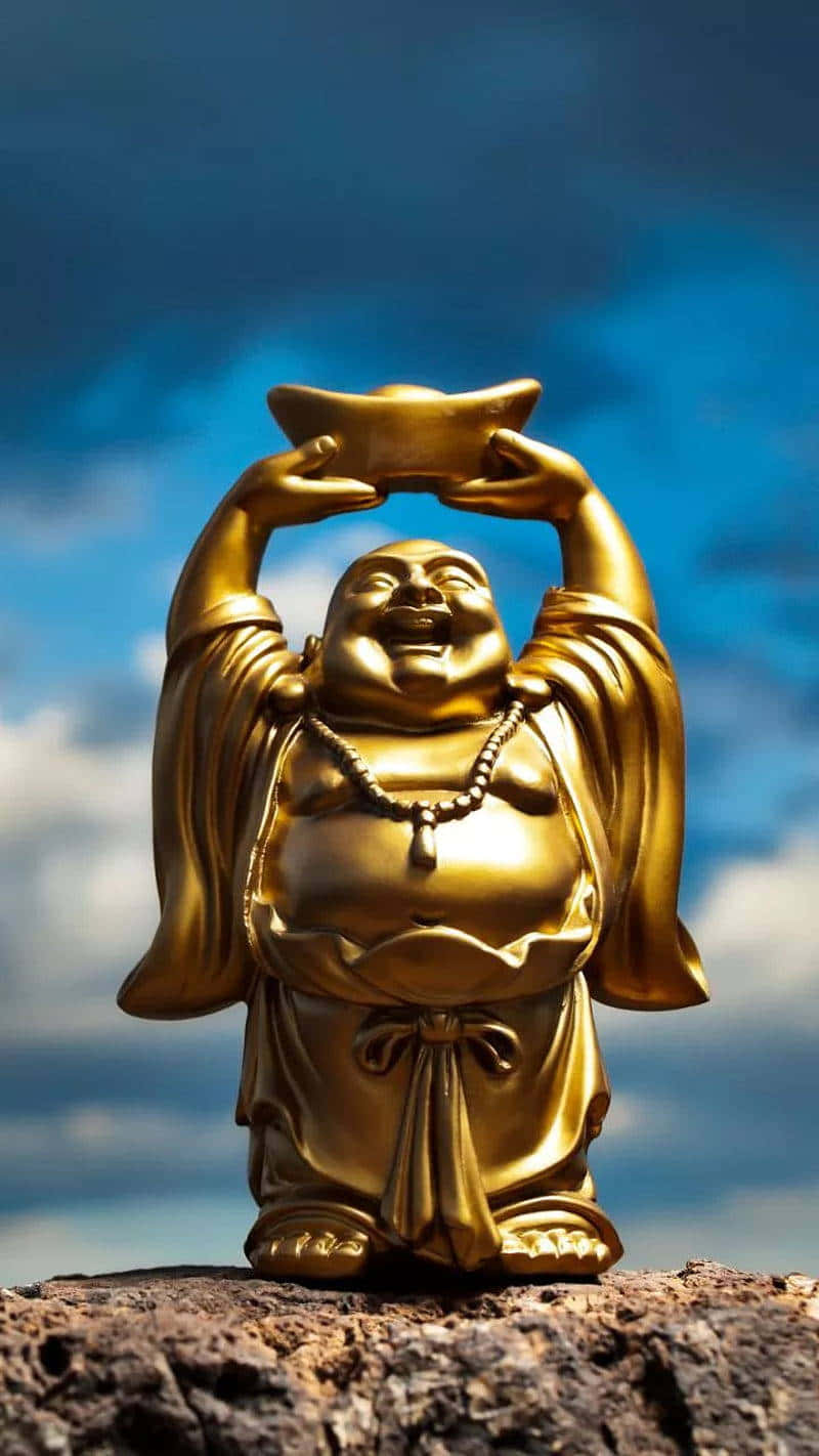 金色笑佛雕像 壁紙 — 金色笑佛雕像喺有 fluffy 雲嘅戲劇性藍天背景下高舉金條。
