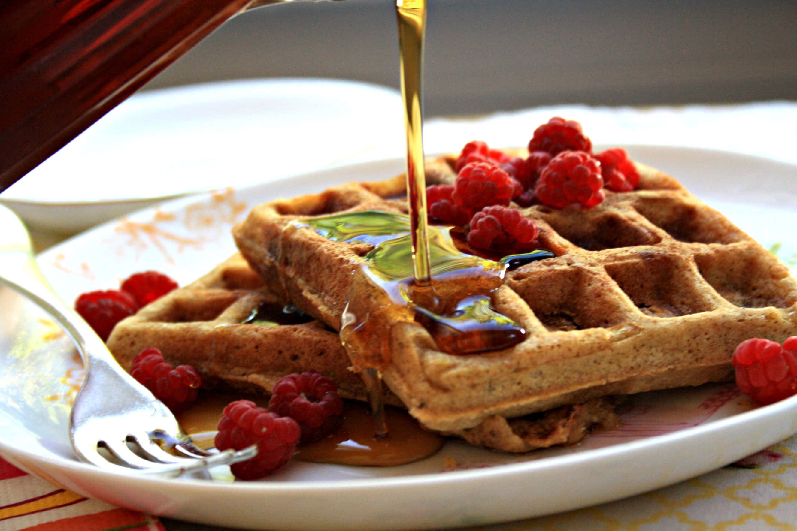 Waffle 桌布 壁紙 — 金色糖漿從白色碟上的新鮮紅桑子窩夫上流下。