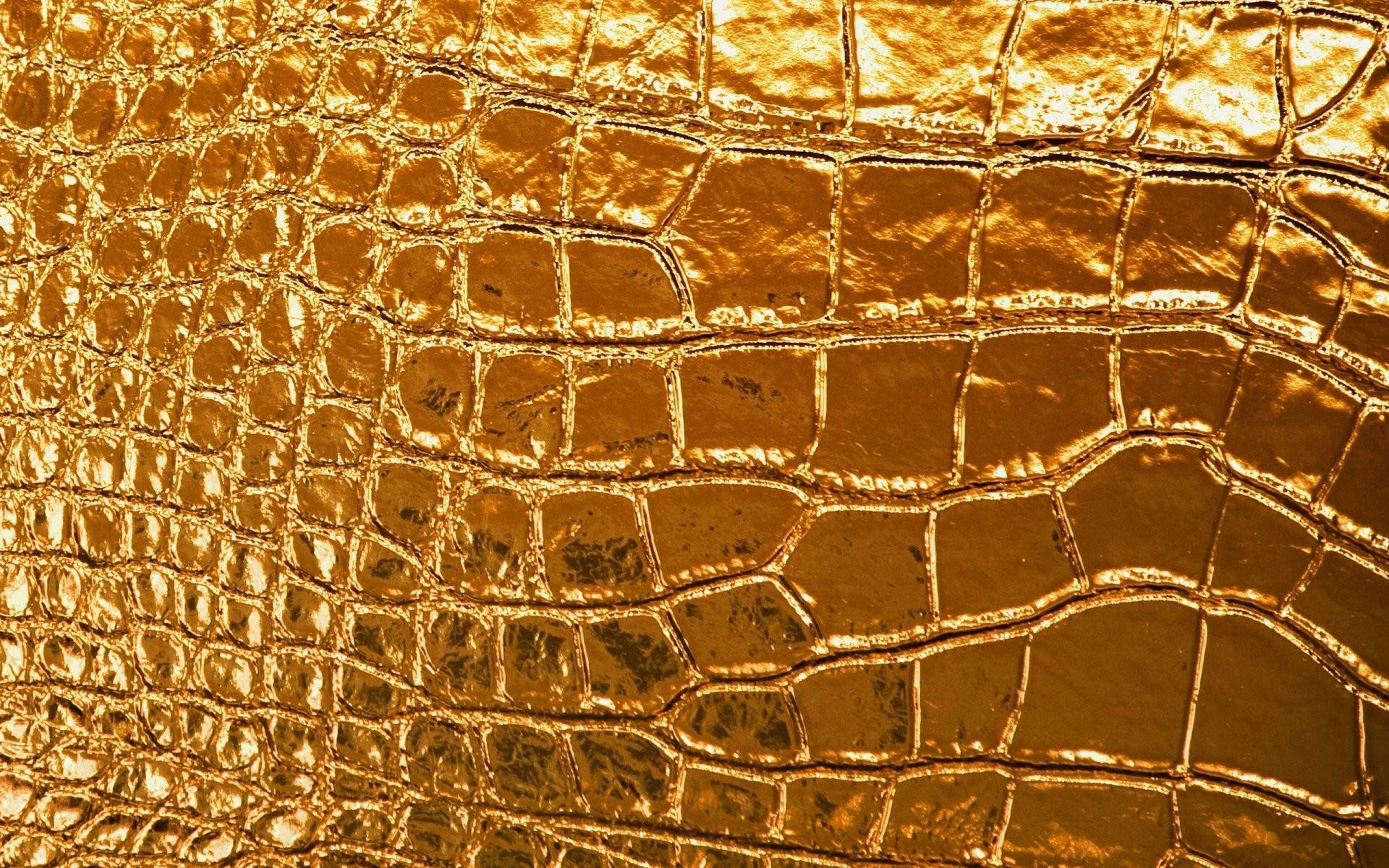 金色鱷魚皮紋理，具有反射鱗片和豐富金屬光澤。