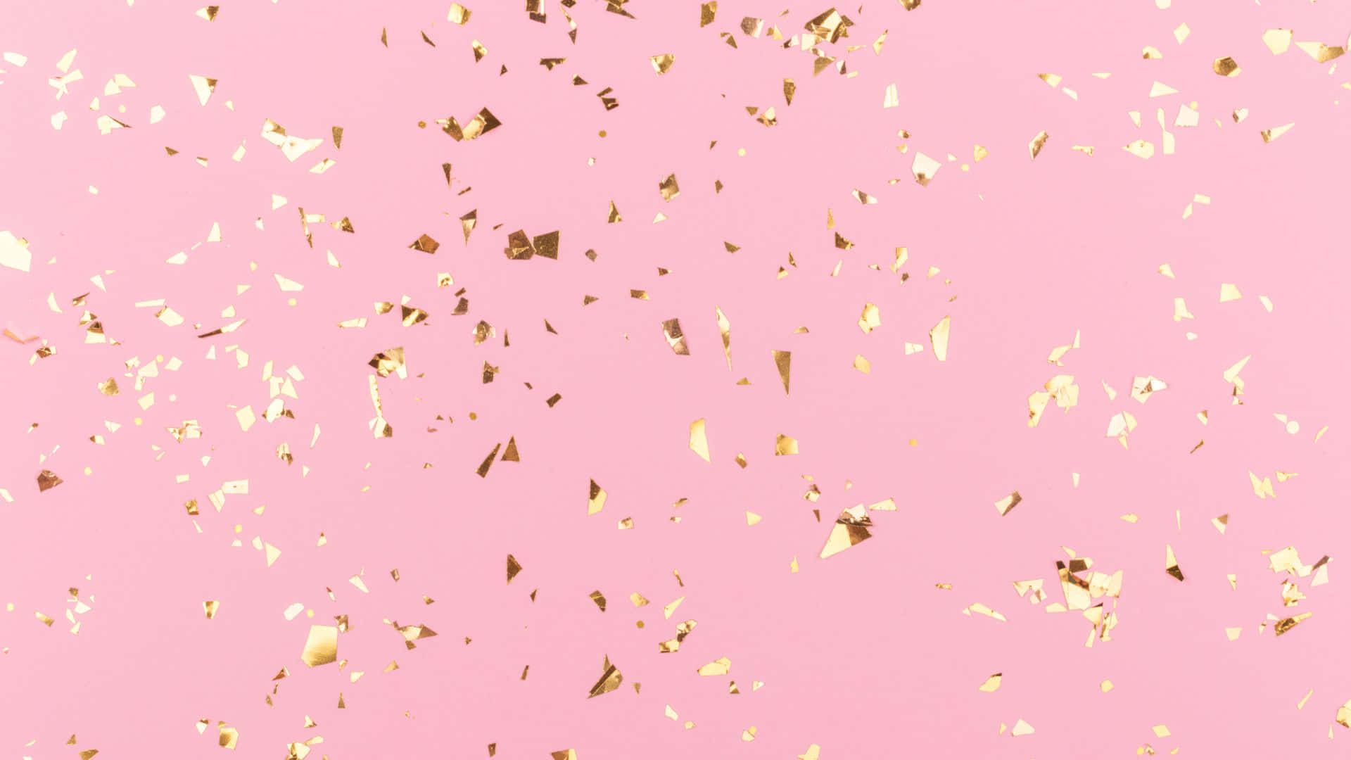 Pink Sparkles 桌布 壁紙 — 金色紙屑在柔和的粉紅色背景上飄浮，營造節日慶祝場景。