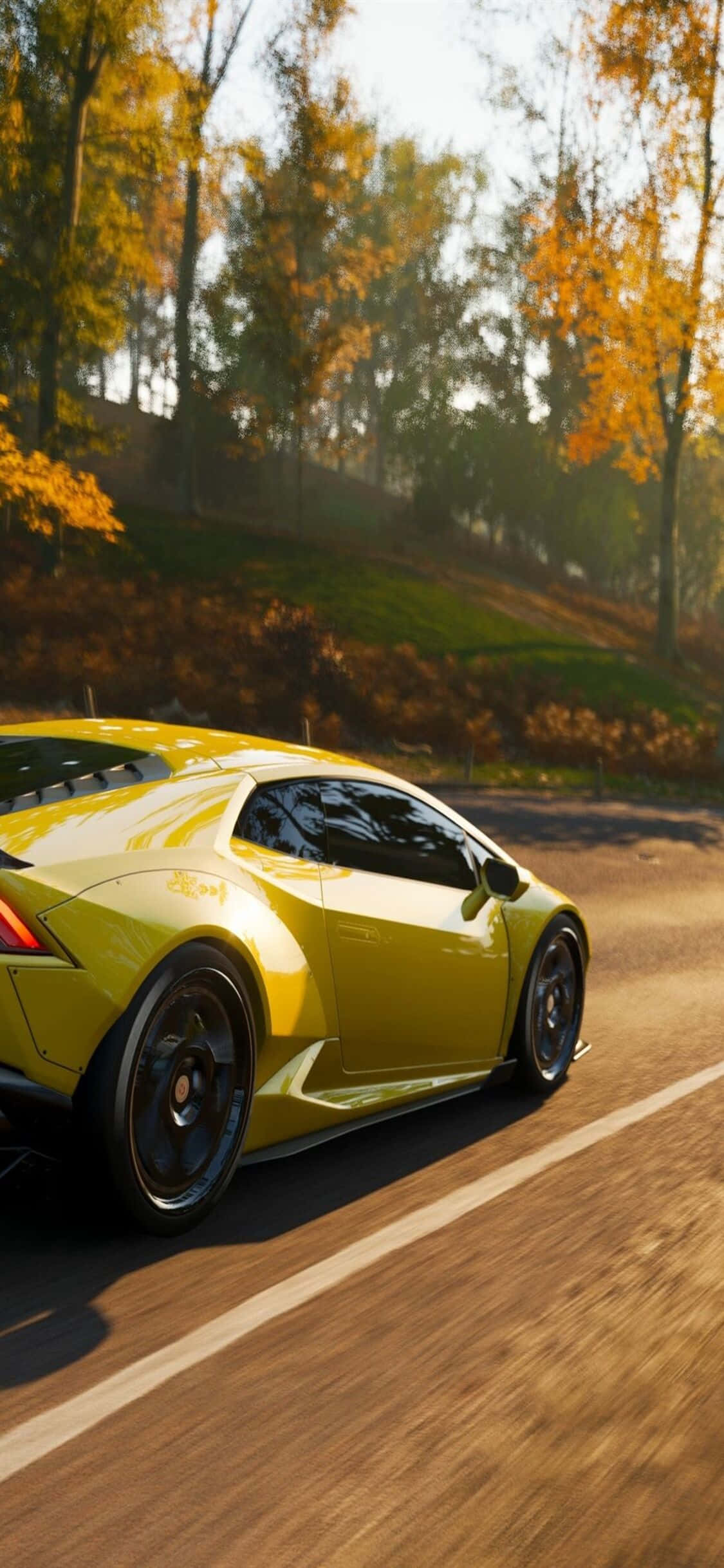 金色蘭博基尼Huracán iPhone X《極限競速7》背景 壁紙 — 一輛充滿活力的黃色跑車沿著蜿蜒的道路穿過金色的秋林飛馳。