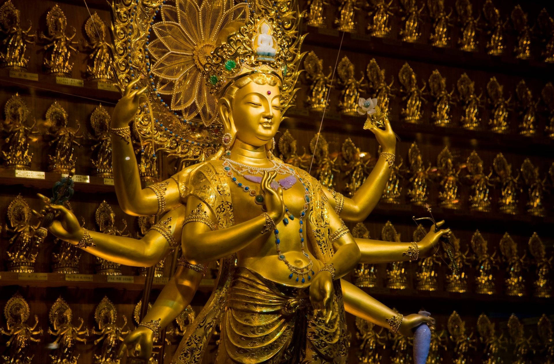 金色多臂佛像被寺廟內較小的金色佛像環繞。