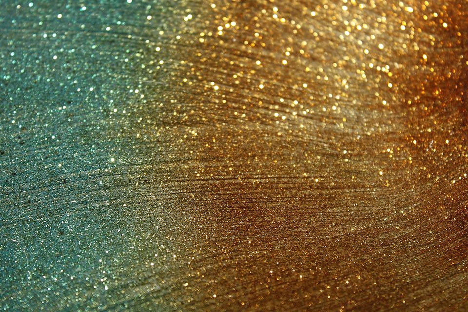 帶有筆觸圖案的閃爍藍綠色和金色閃粉紋理。